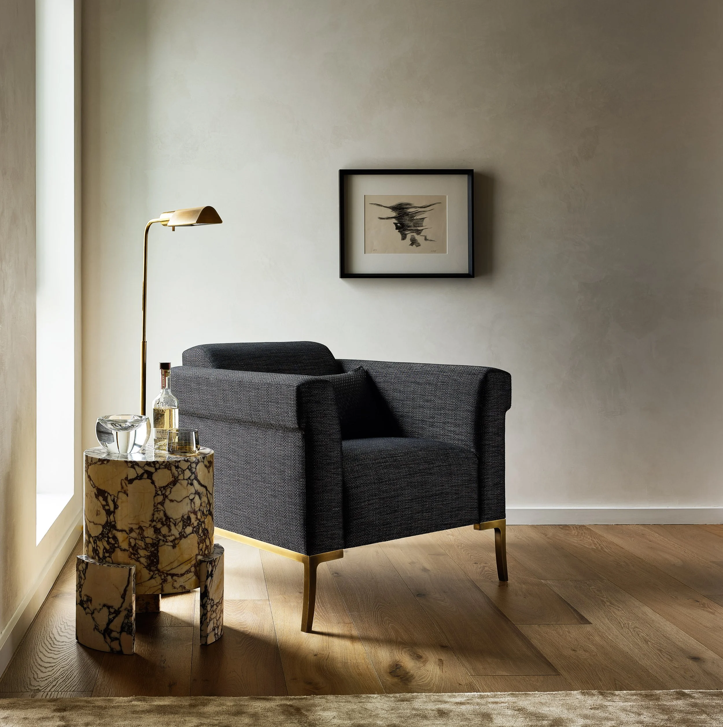 Broadway Penthouse Pacific Heights living room corner with a dark gray lounge chair, marble side table styled with water and candle, and a sculptural floor lamp beside abstract art for calm modern luxury in San Francisco.