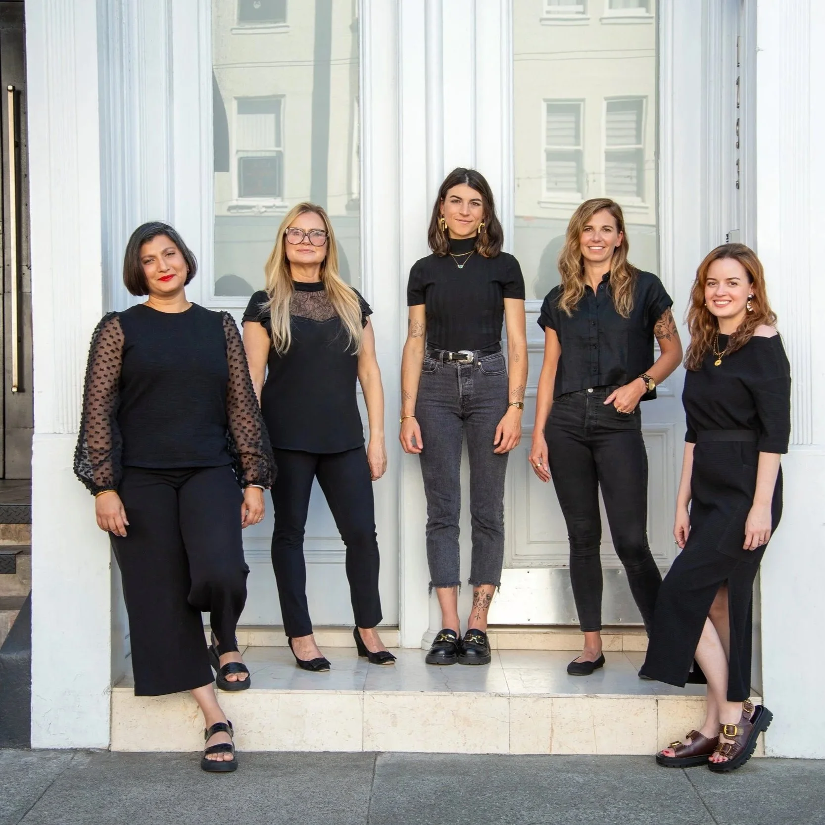 ballonSTUDIO team with Sabra Ballon standing together outside a bright entry, dressed in black and smiling, representing a boutique San Francisco interior design studio known for refined, full service residential projects.  .