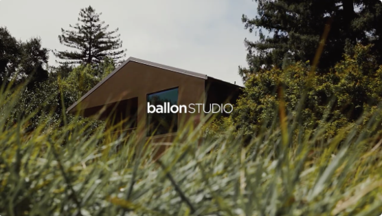 A building with the logo 'ballon STUDIO' on it, surrounded by trees and grass.
