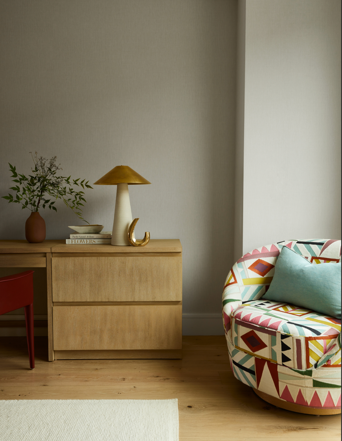 Union Street Marina District living room corner in San Francisco with wood sideboard, sculptural lamp, greenery, and a colorful patterned chair, blending curated styling and warm materials for modern luxury interior design.