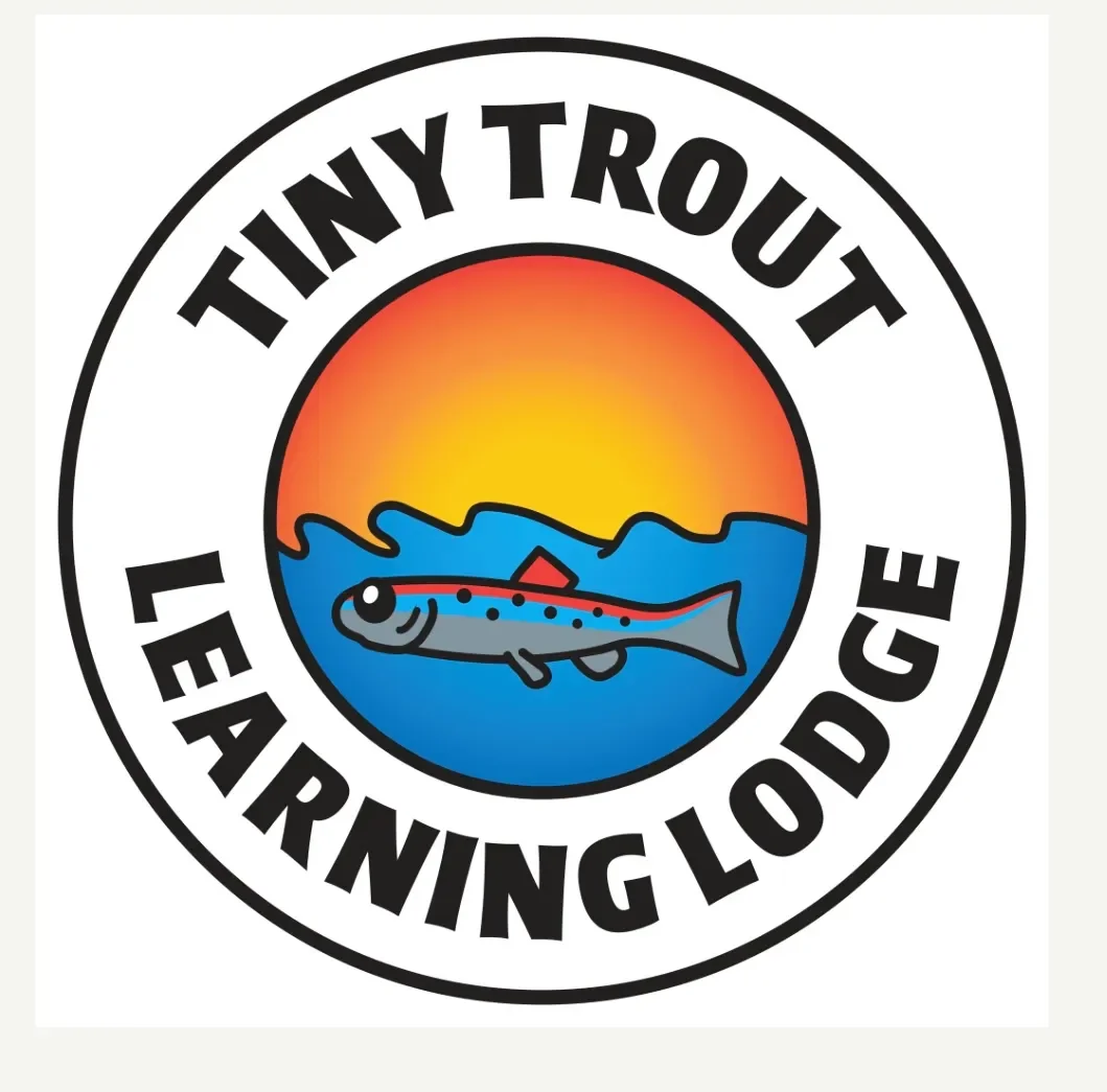 A circular logo featuring a sunset over ocean waves, with a small fish in the foreground. The text around the circle reads 'Tiny Trot Learning Lodge'.