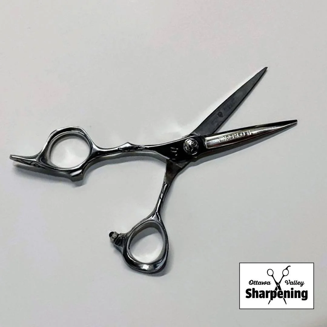 Hair cutting scissors on a white surface with a logo that says Ottawa Valley Sharpening.