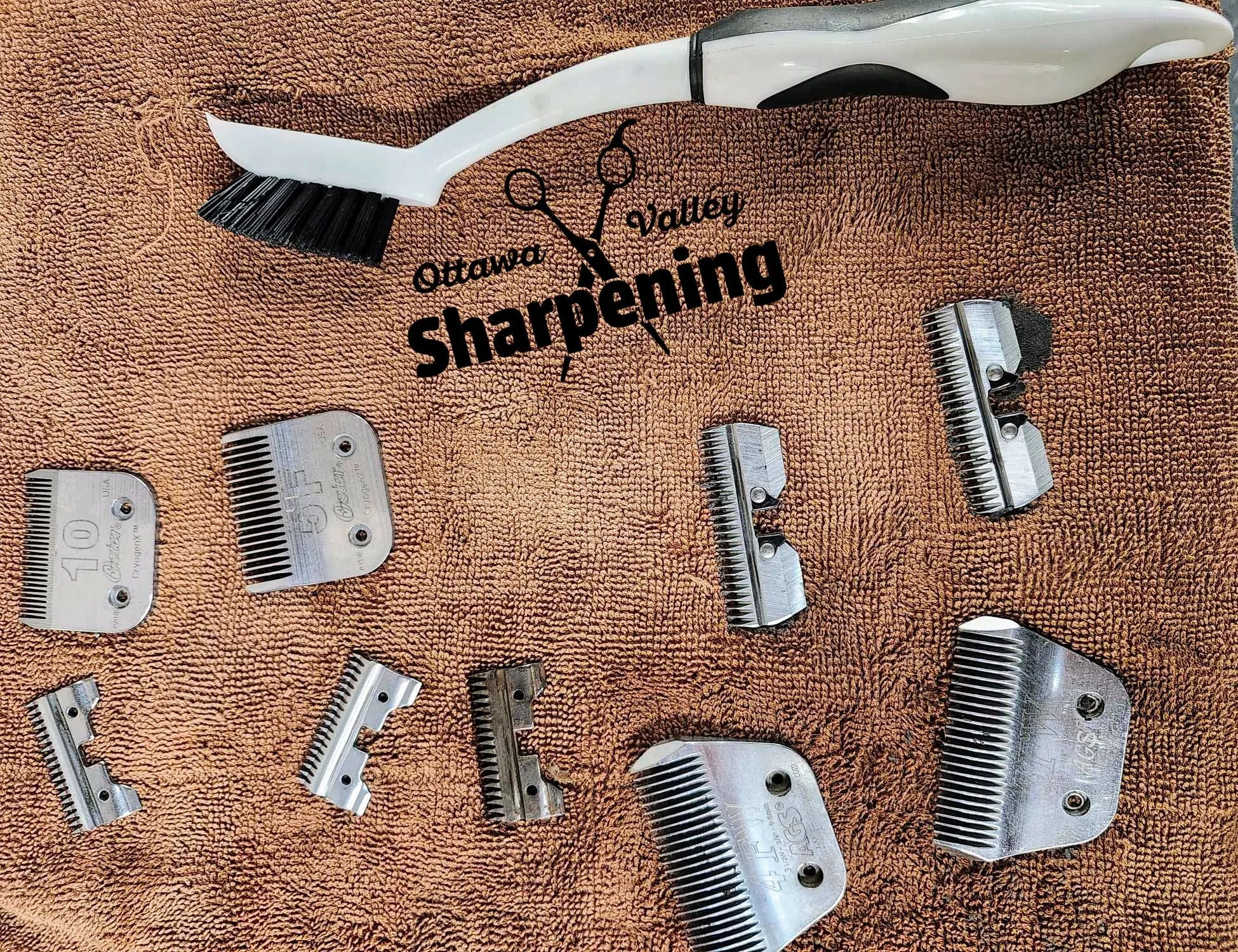 Various clipper blade combs and a brush on an orange towel with the logo 'Ottawa Valley Sharpening'.