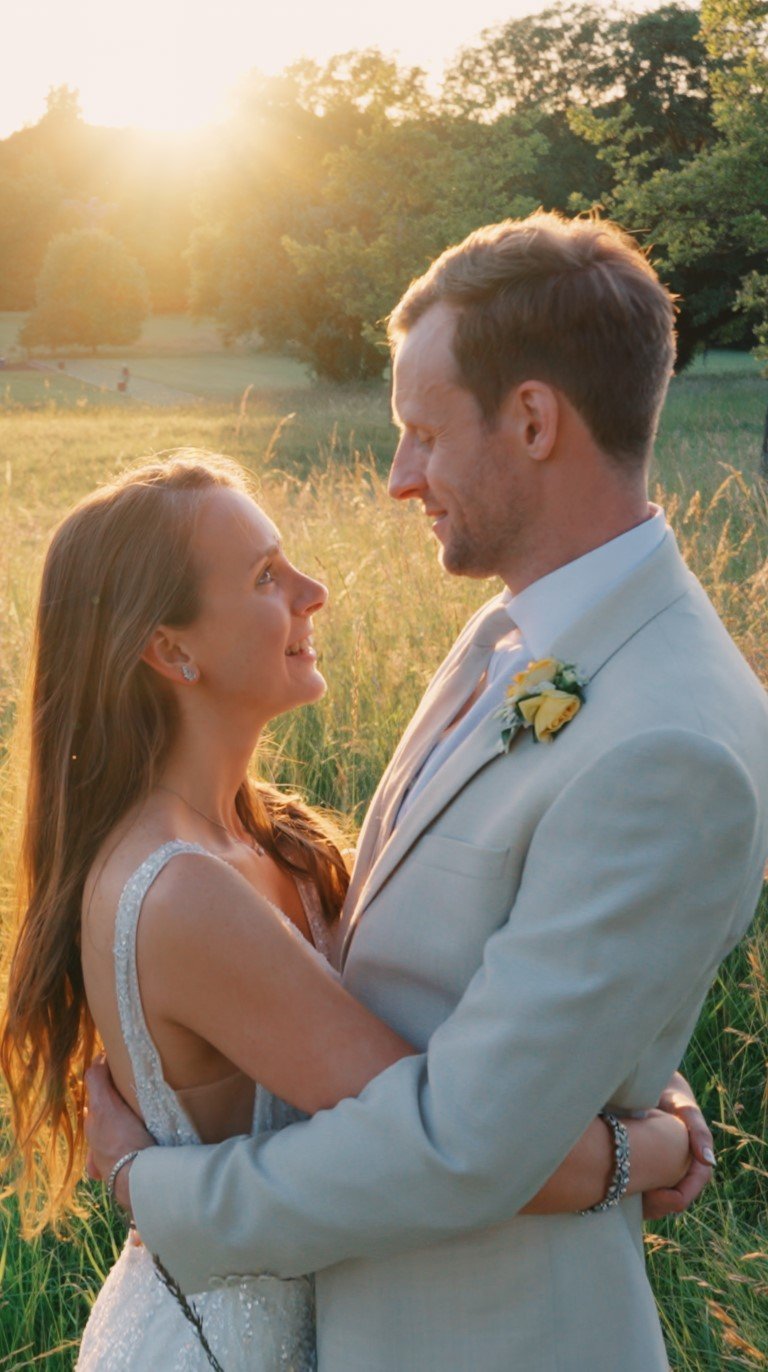 Bride and groom standing close together at sunset during their wedding, sharing a quiet moment outdoors.