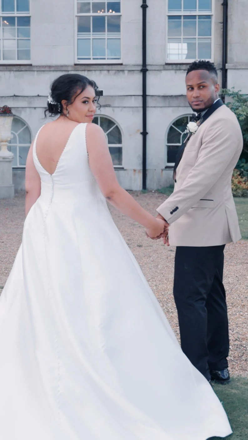 Bride and groom holding hands outside their wedding venue, photographed naturally on their wedding day.