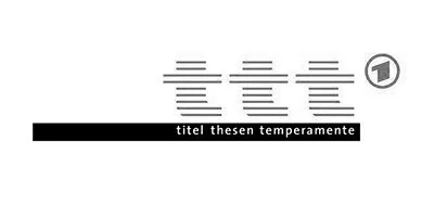 Ein büroartiger Arbeitsplatz mit einem Computerbildschirm, auf dem Symbole und Text zu sehen sind, sowie eine schwarze Leiste mit der Aufschrift 'titel thesen temperamente'.