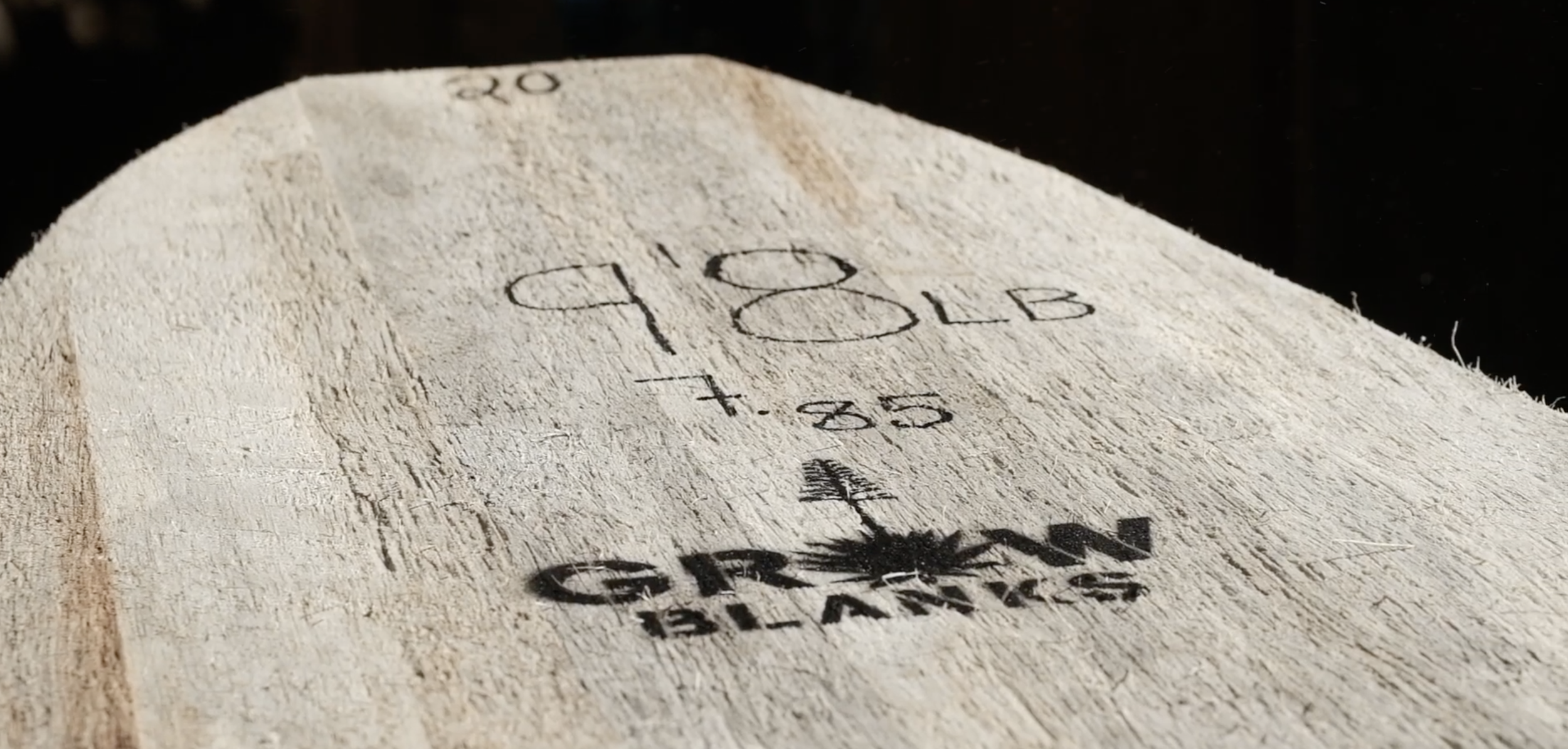 Close-up of a wooden white agave board with handwritten black ink markings, including the number 180 LB, a plus sign, and the words 'GROW BLANKS' with an agave leaf graphic.