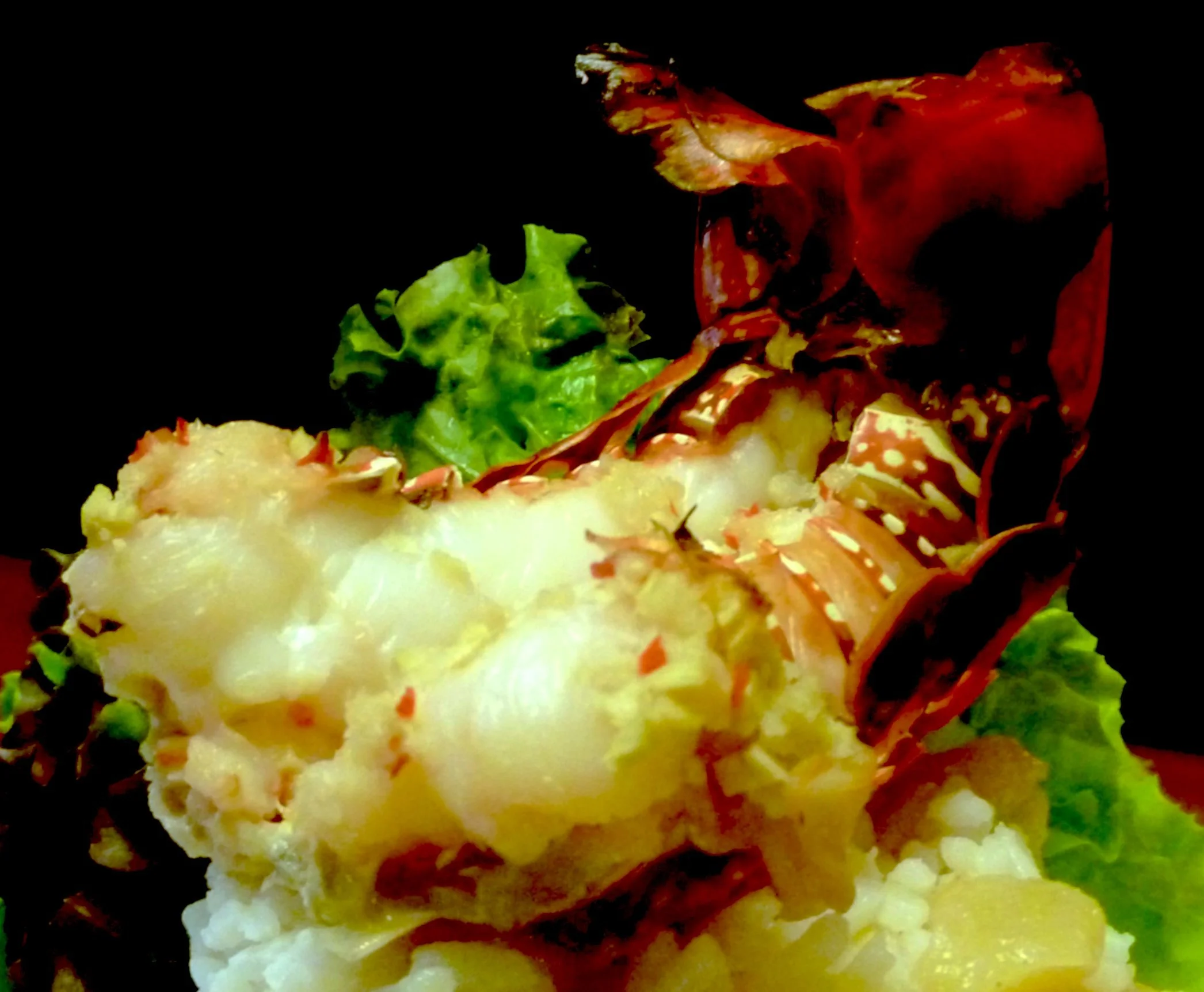 A serving of lobster tail in ginger sauce garnished with leafy greens.