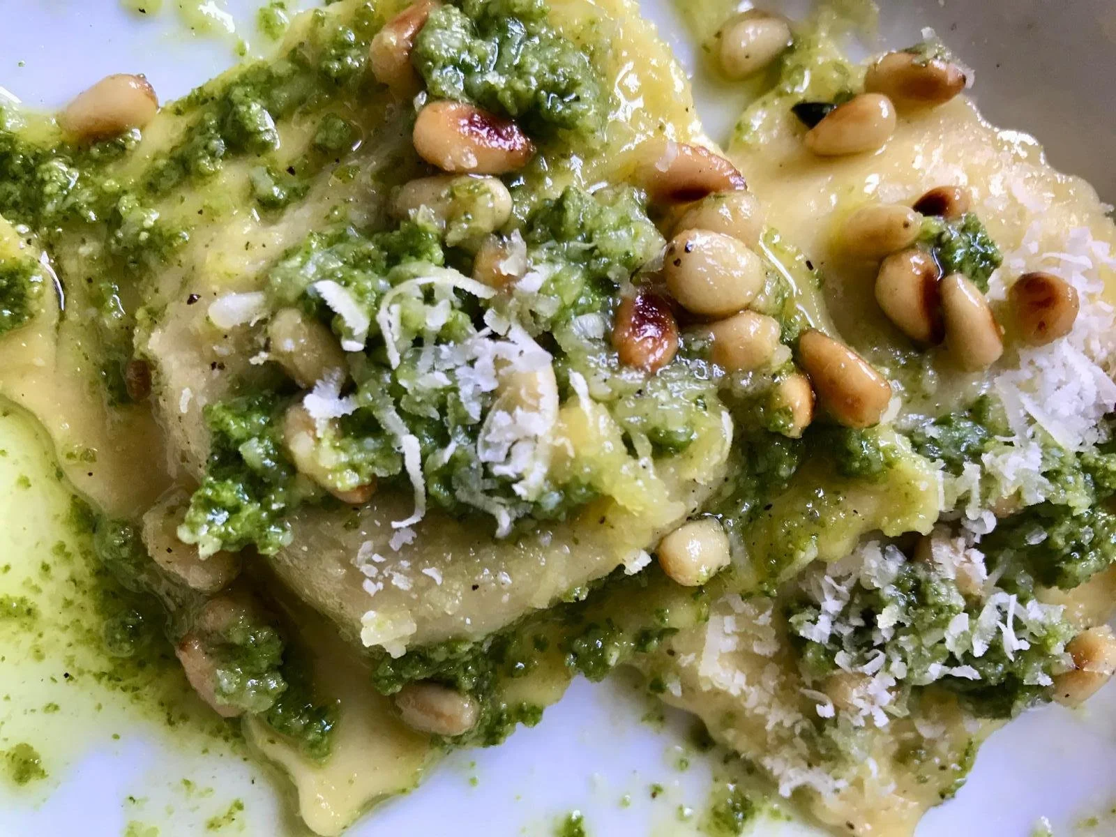 image showing homemade ravioli pasta with pesto, pine nuts and parmesan shavings