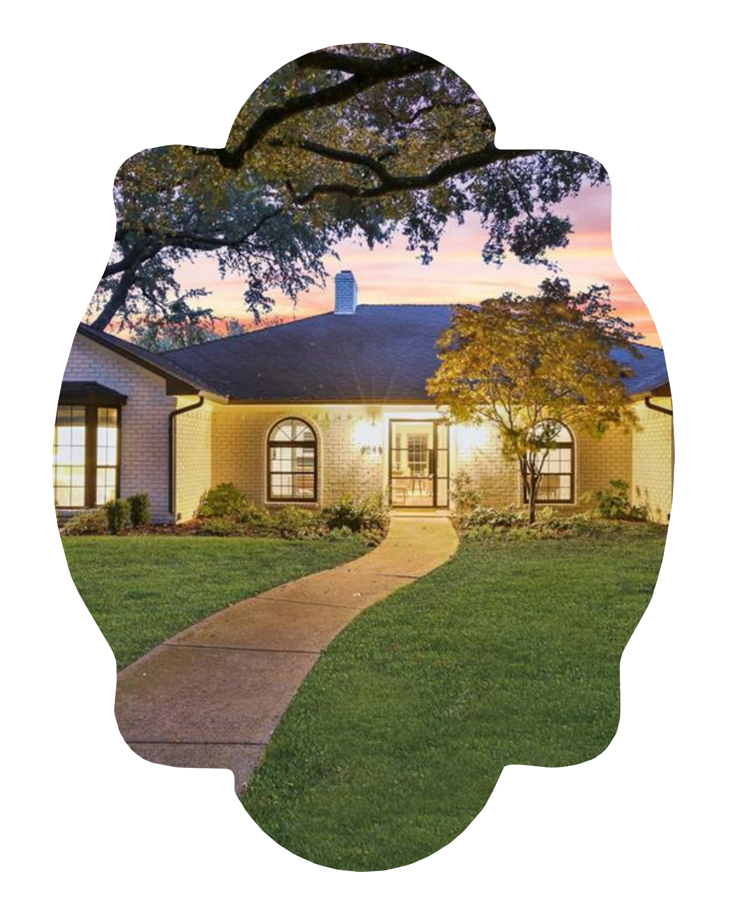 A house with a brick exterior at sunset, with trees in the front yard and a curved walkway leading to the front door.