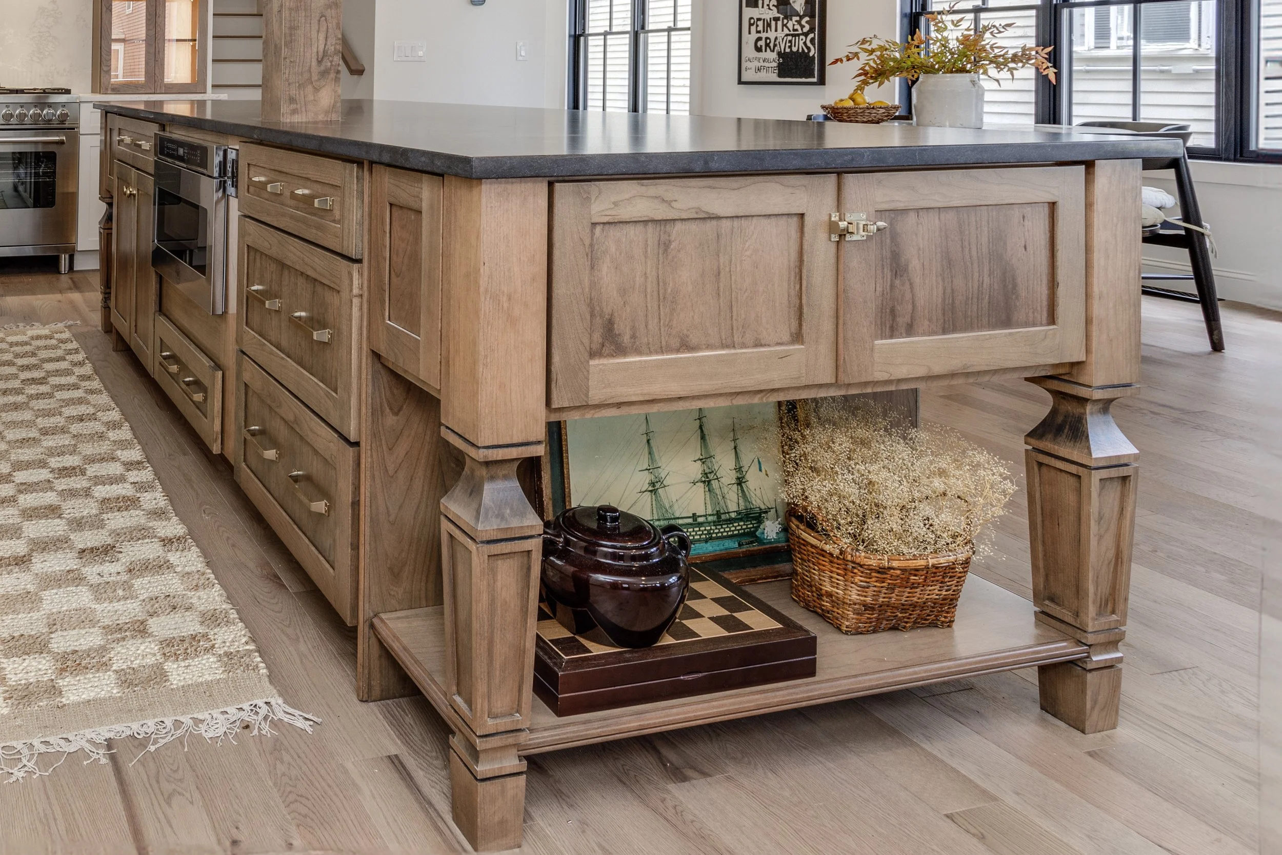 custom wood kitchen island with honed countertop and brass hardware installed by New Hampshire contractor