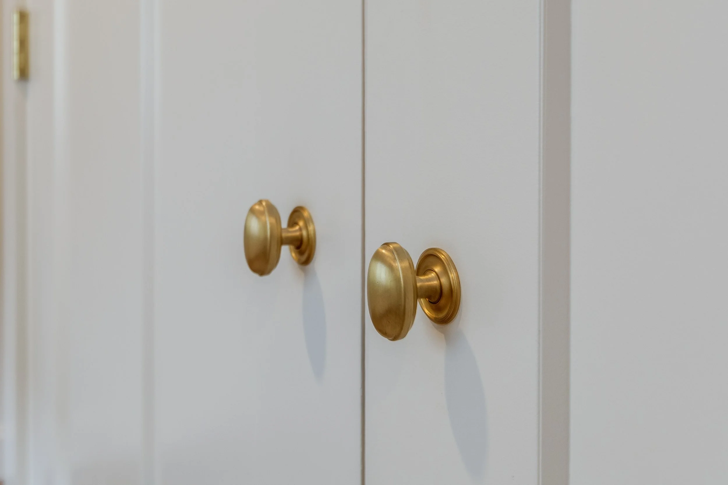 brass cabinet knobs on white cabinetry installed project New Hampshire finish specialist Builder's Reserve