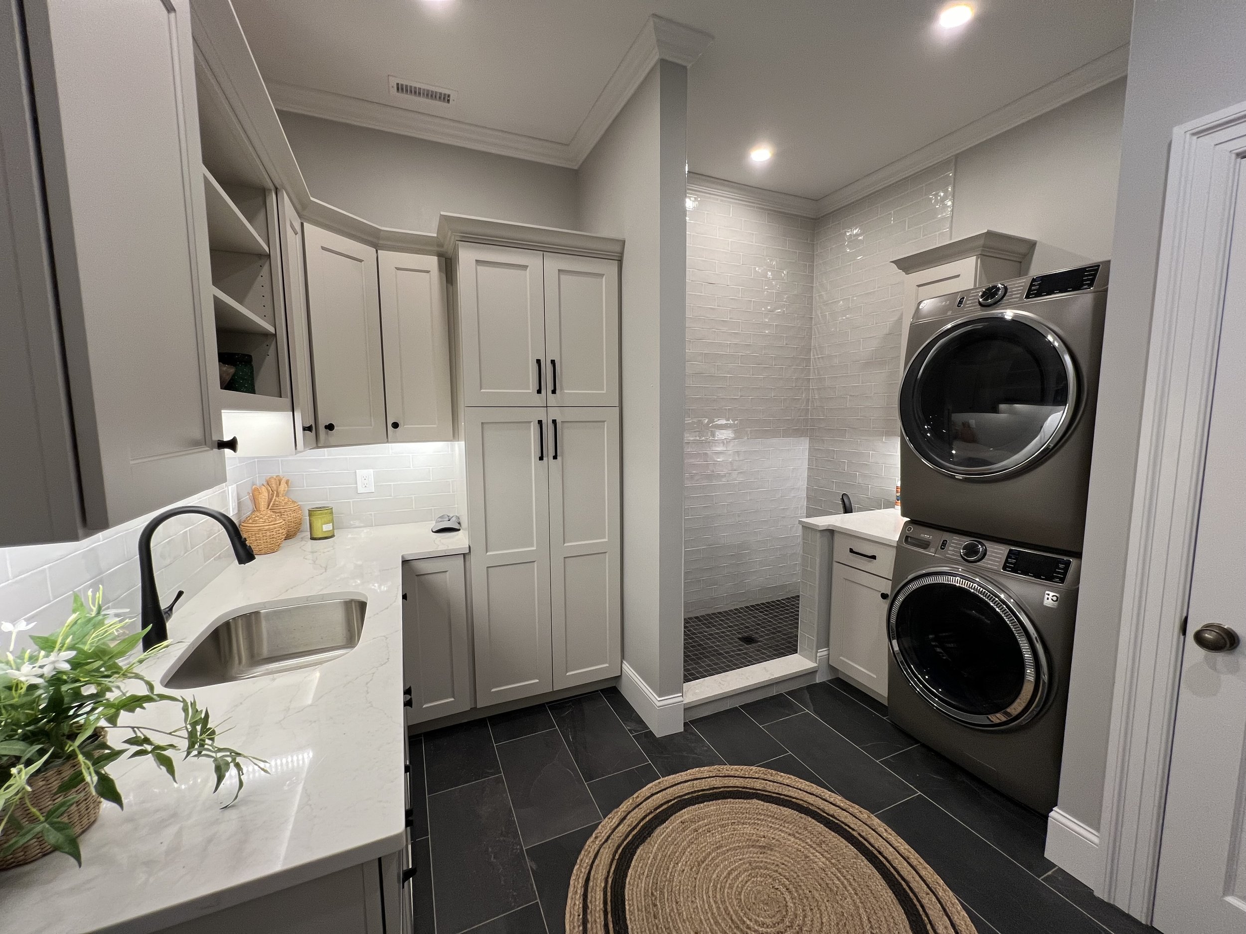 Custom laundry room gray cabinets stacked washer dryer built-in storage Topsfield