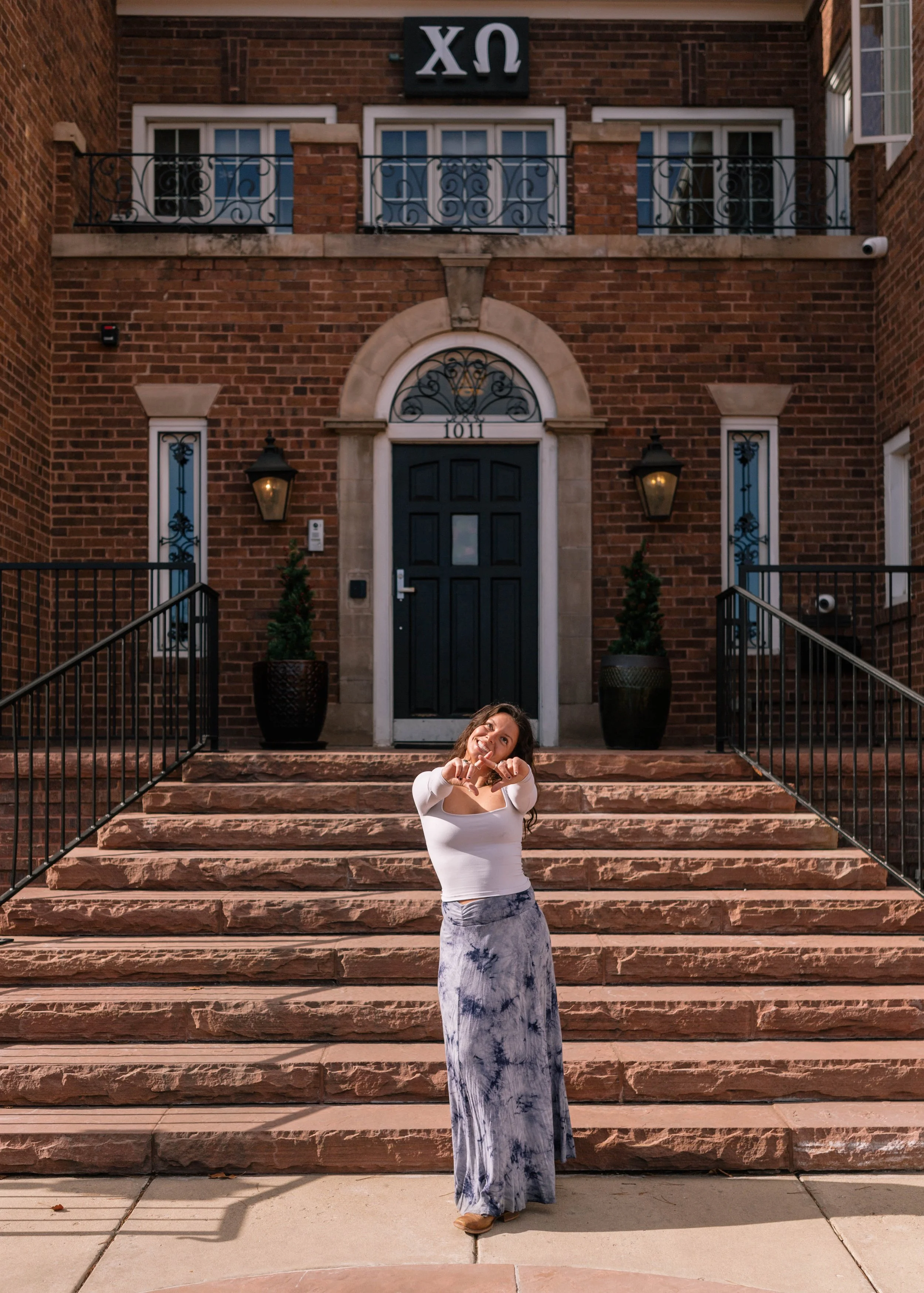 CU Boulder senior portrait on campus steps in front of historic brick building