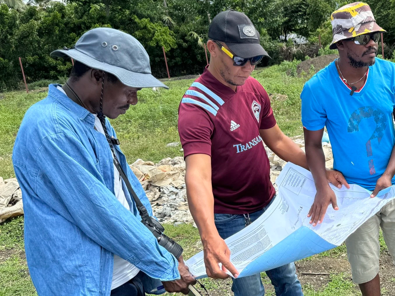men in the field looking at a site plan