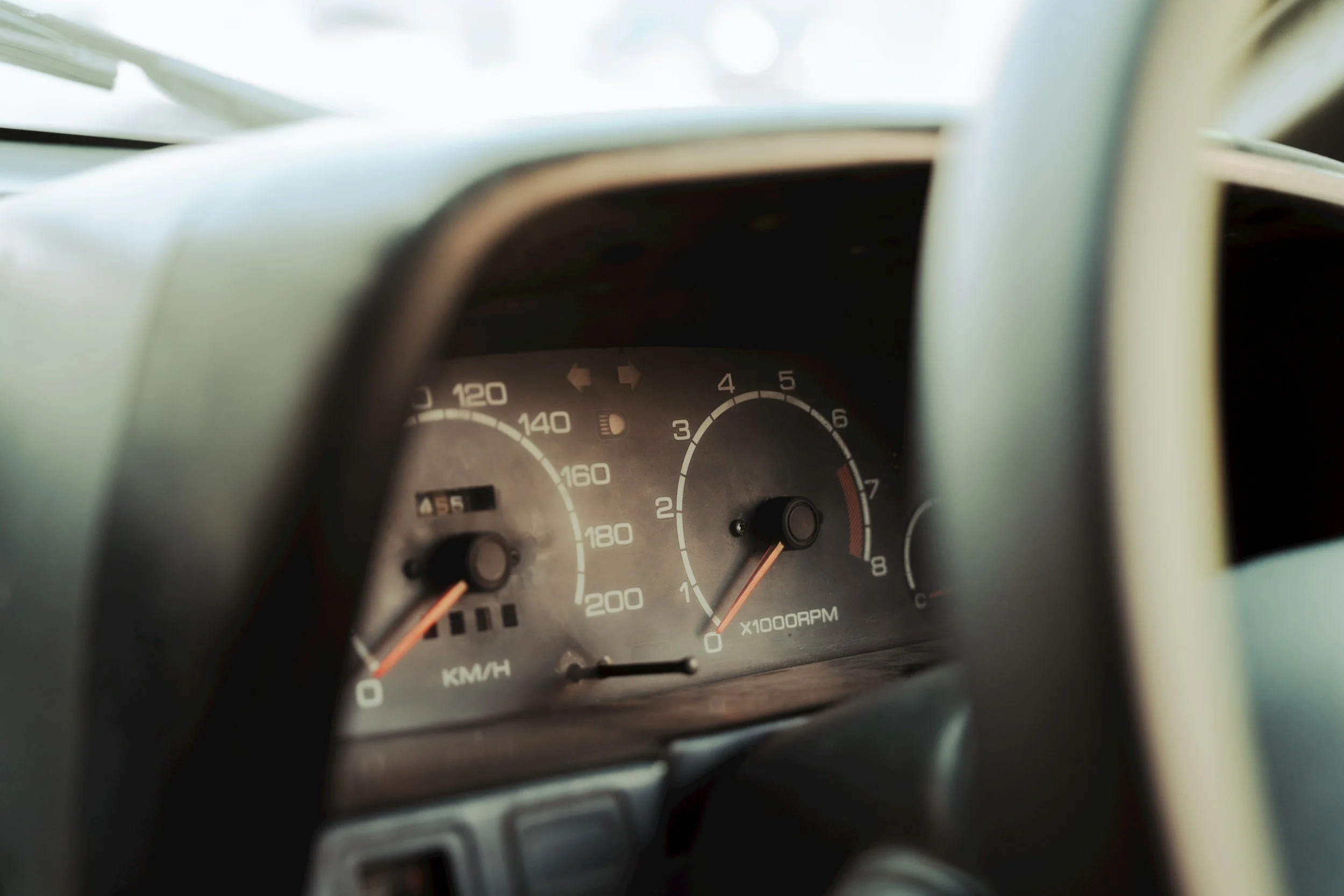 Close-up of a car dashboard showing a speedometer, tachometer, and fuel gauge.