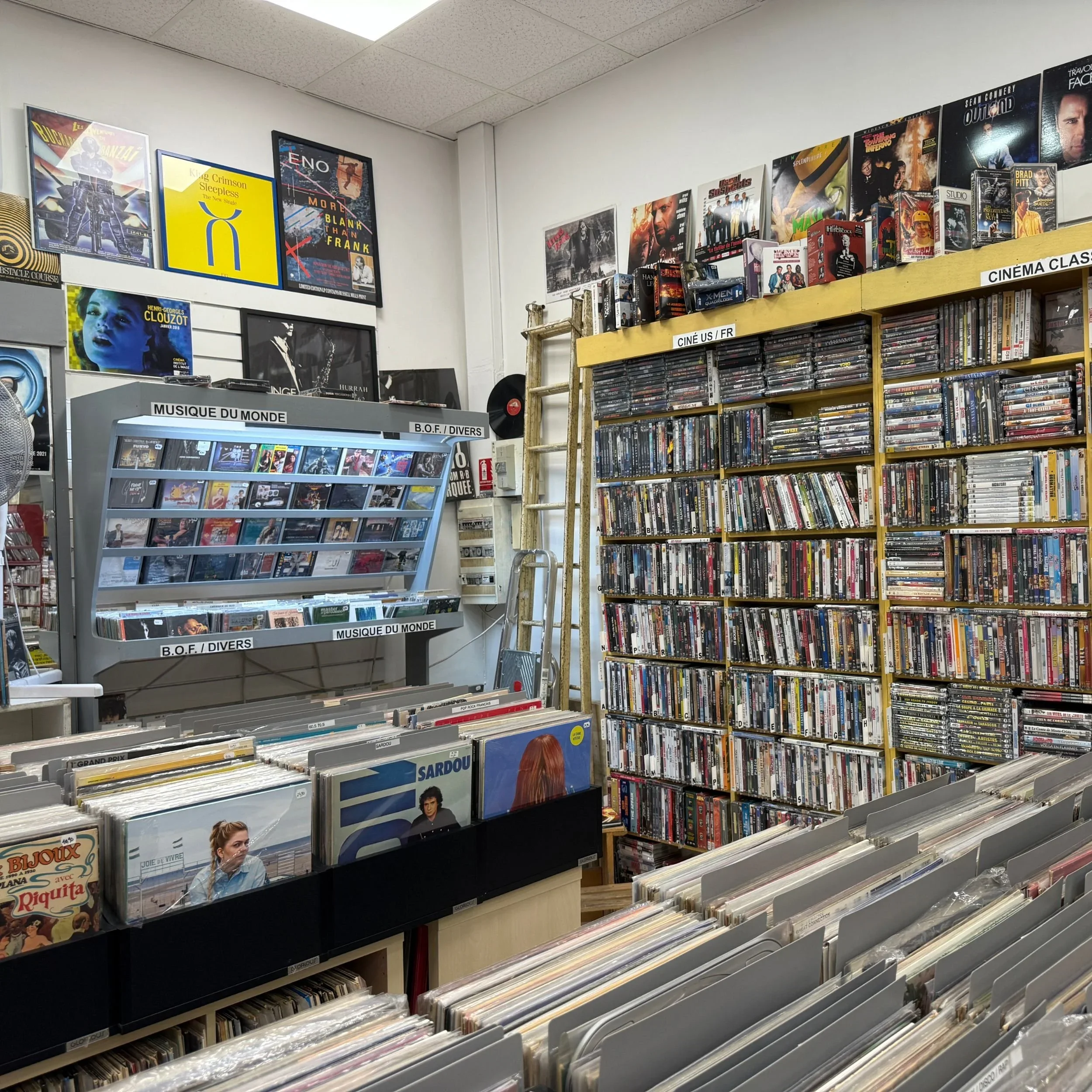 Intérieur d’un magasin de musique et de vinyles à Aix-en-Provence avec bacs de disques et rayons de DVD