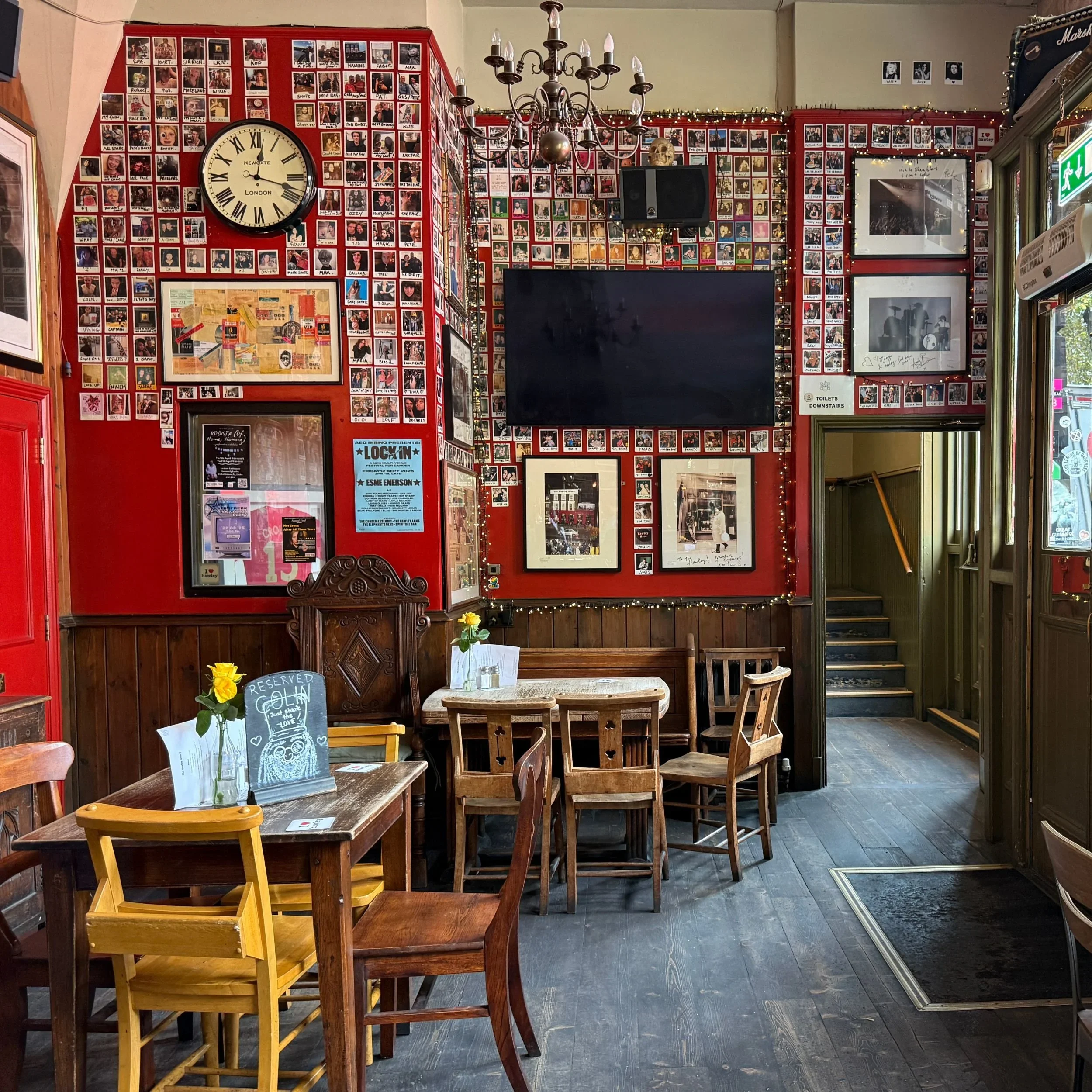 Red lined walls with music memorabilia at the Hawley Arms pub