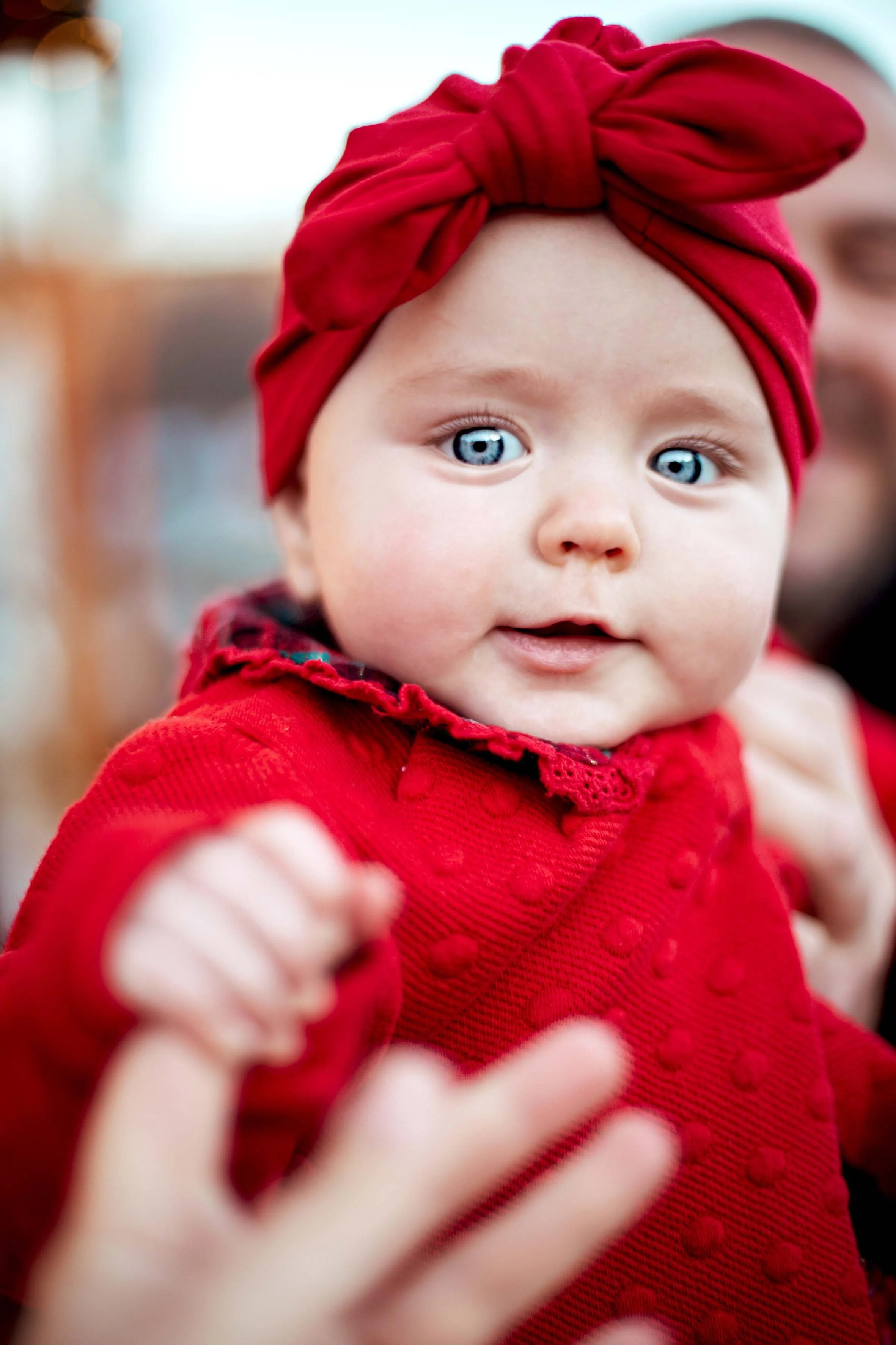 beautiful baby with blue eyes dressed in red professional baby photoshoot
