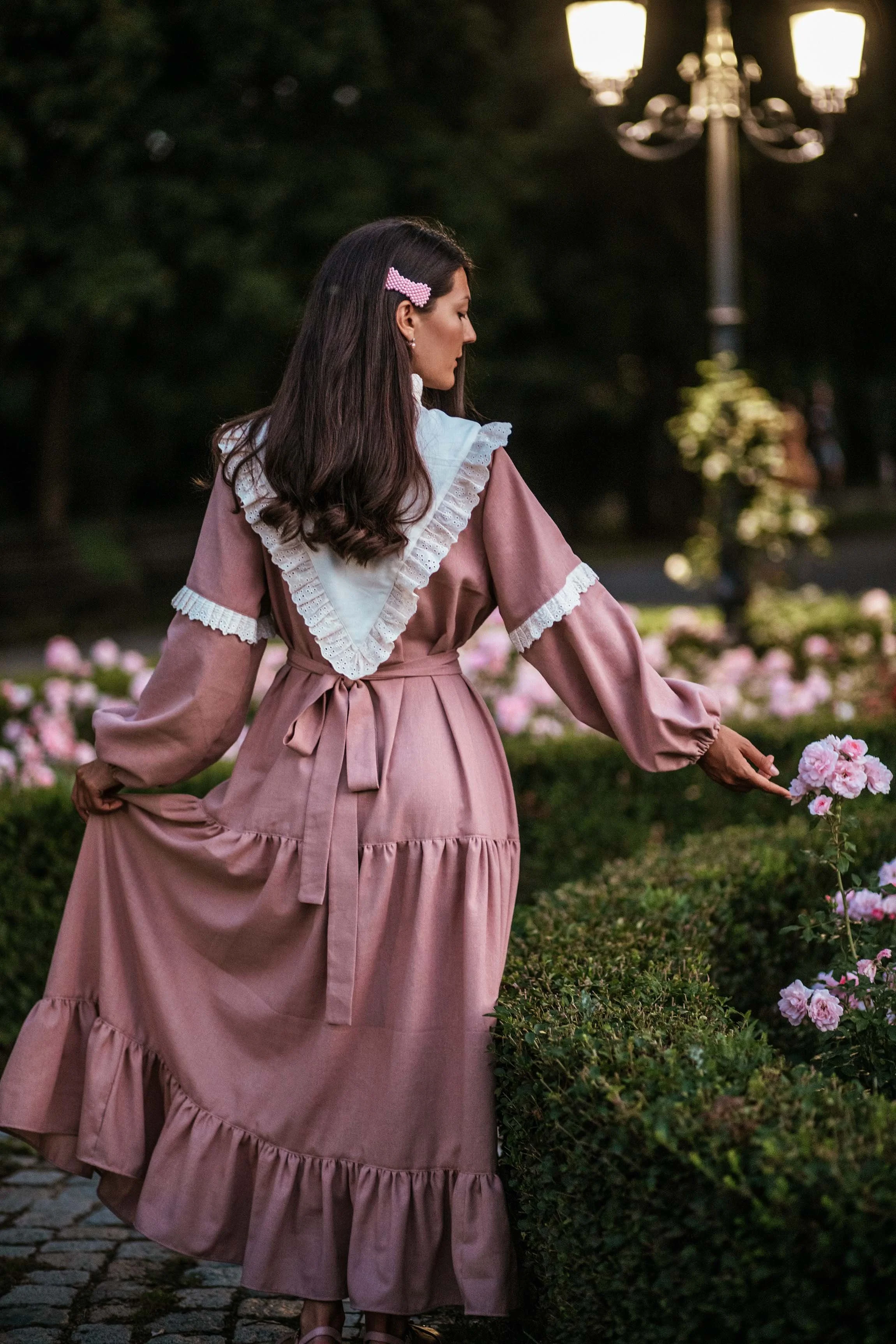 lady in pink bohemian dress walking in the garden of roses professional photoshoot