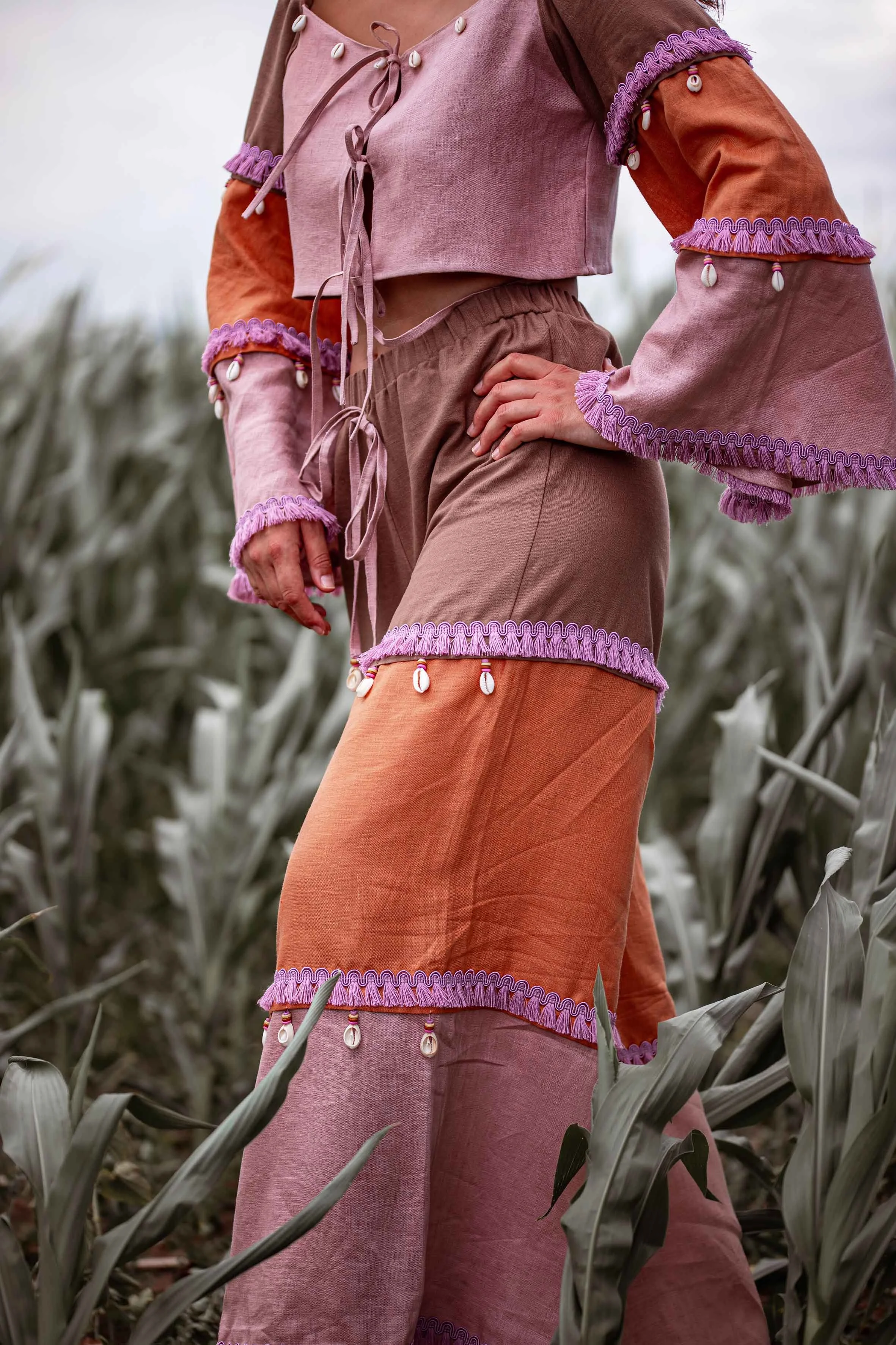product fashion photoshoot boho set widely pants and top with seashells colourful in the field