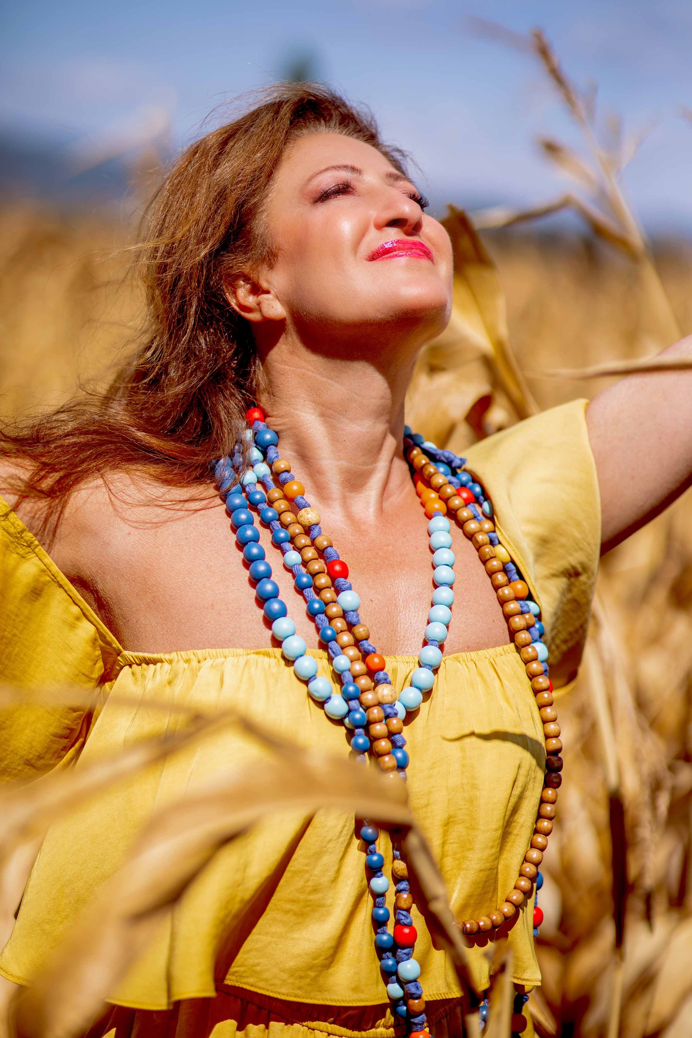 a free soul woman in yellow in the fields