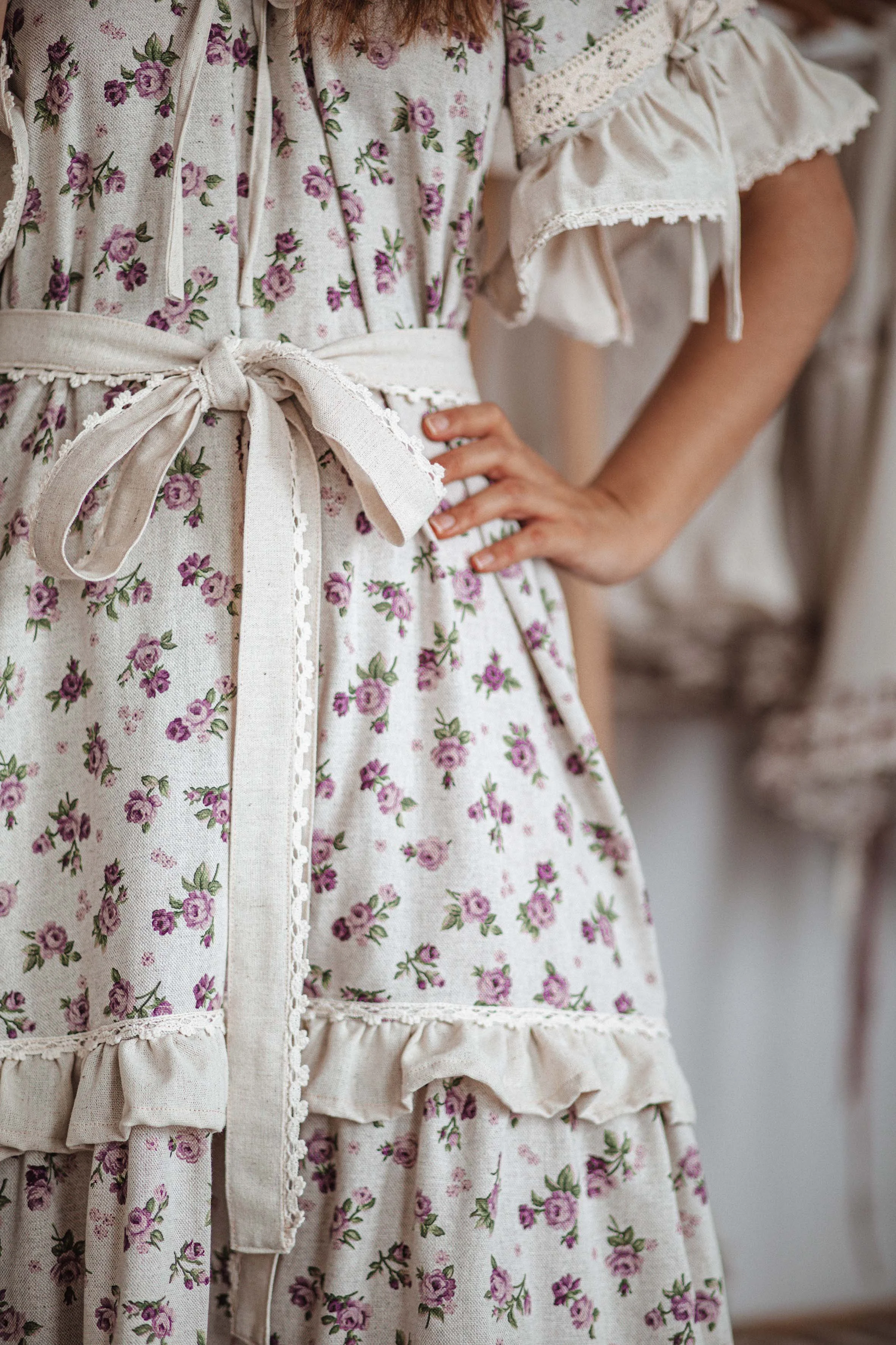 fashion photoshoot detail of a boho dress with purple roses with lace
