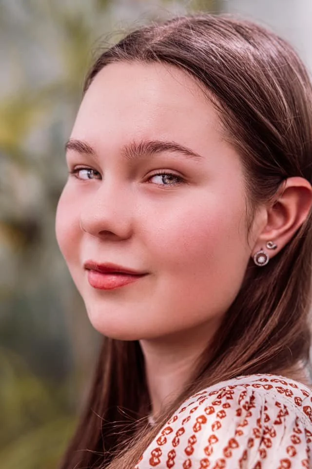 young girl with blue eyes  in a botanical garden