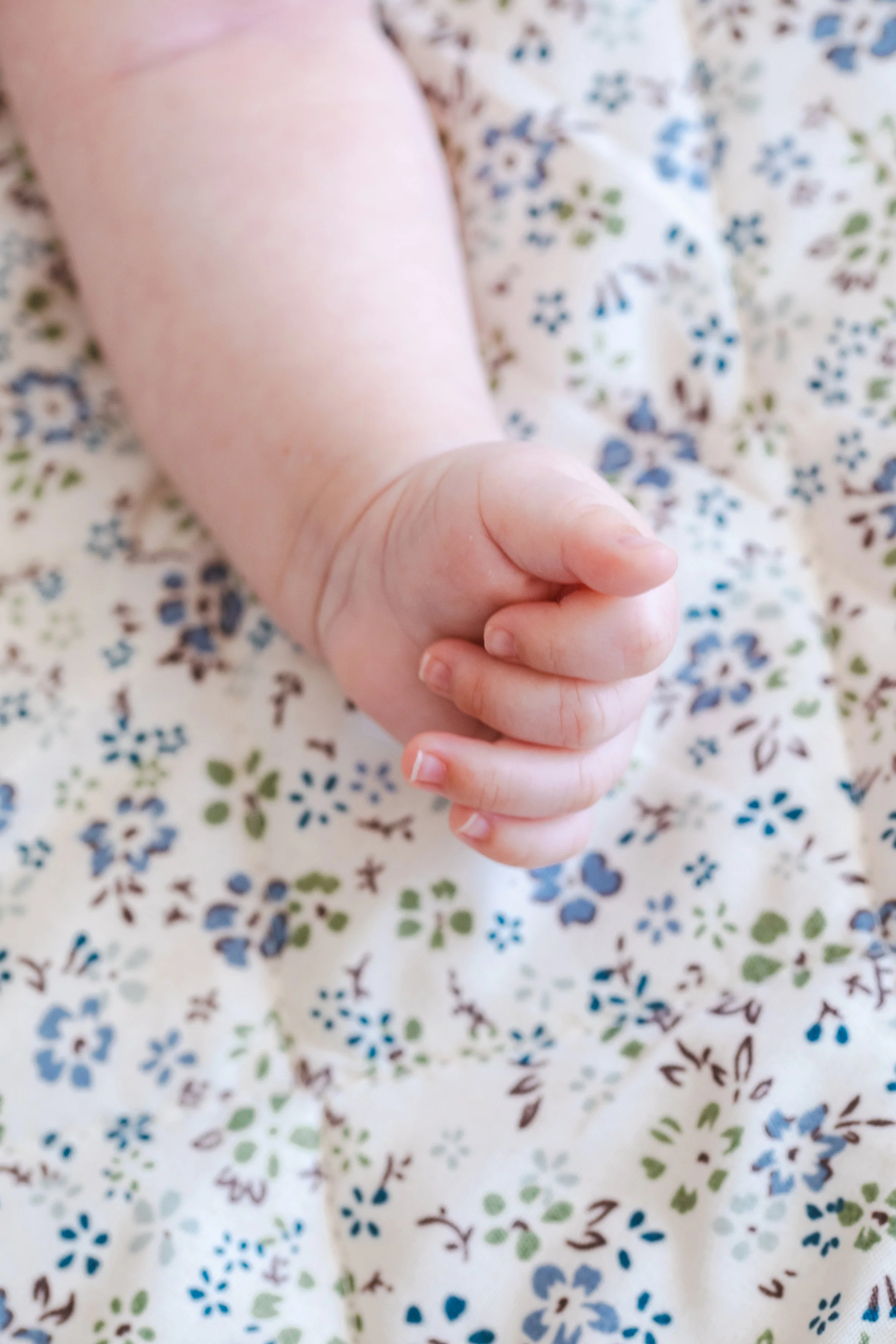 cute baby hand in blue sheets