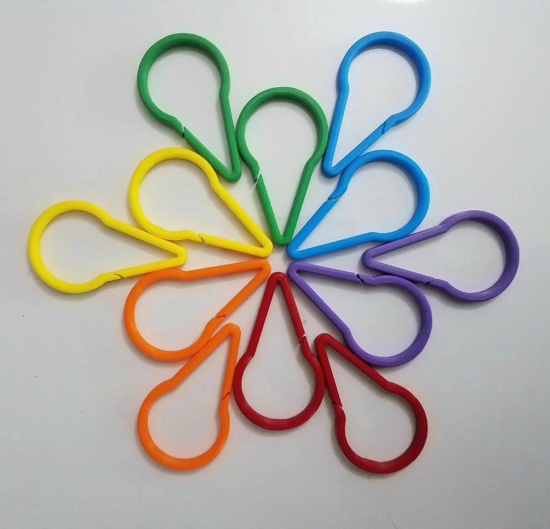 Colorful plastic paperclips arranged in a circular pattern on a white background.