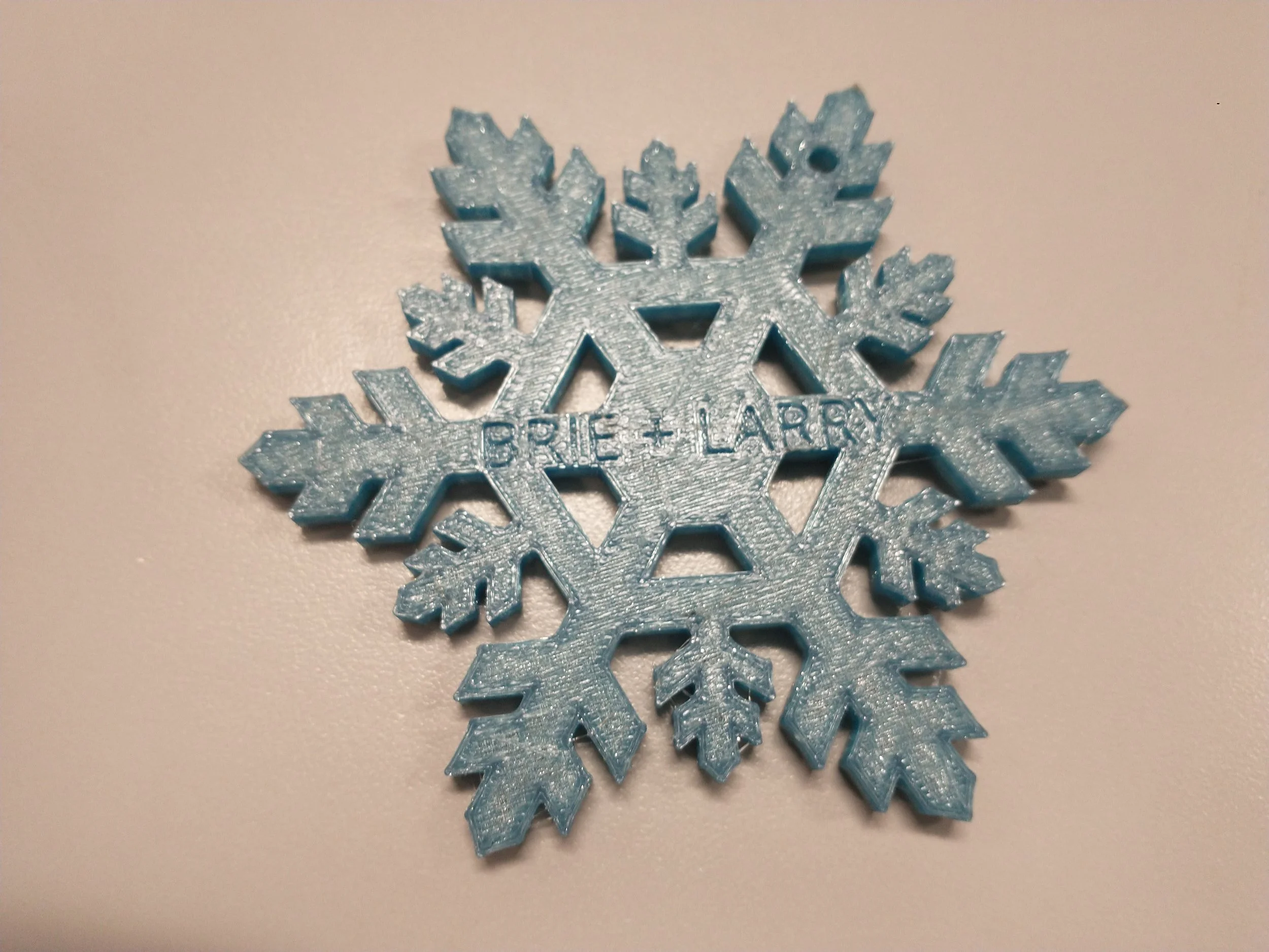 Blue foam snowflake with the words 'BRIE + LARRY' engraved in the center.