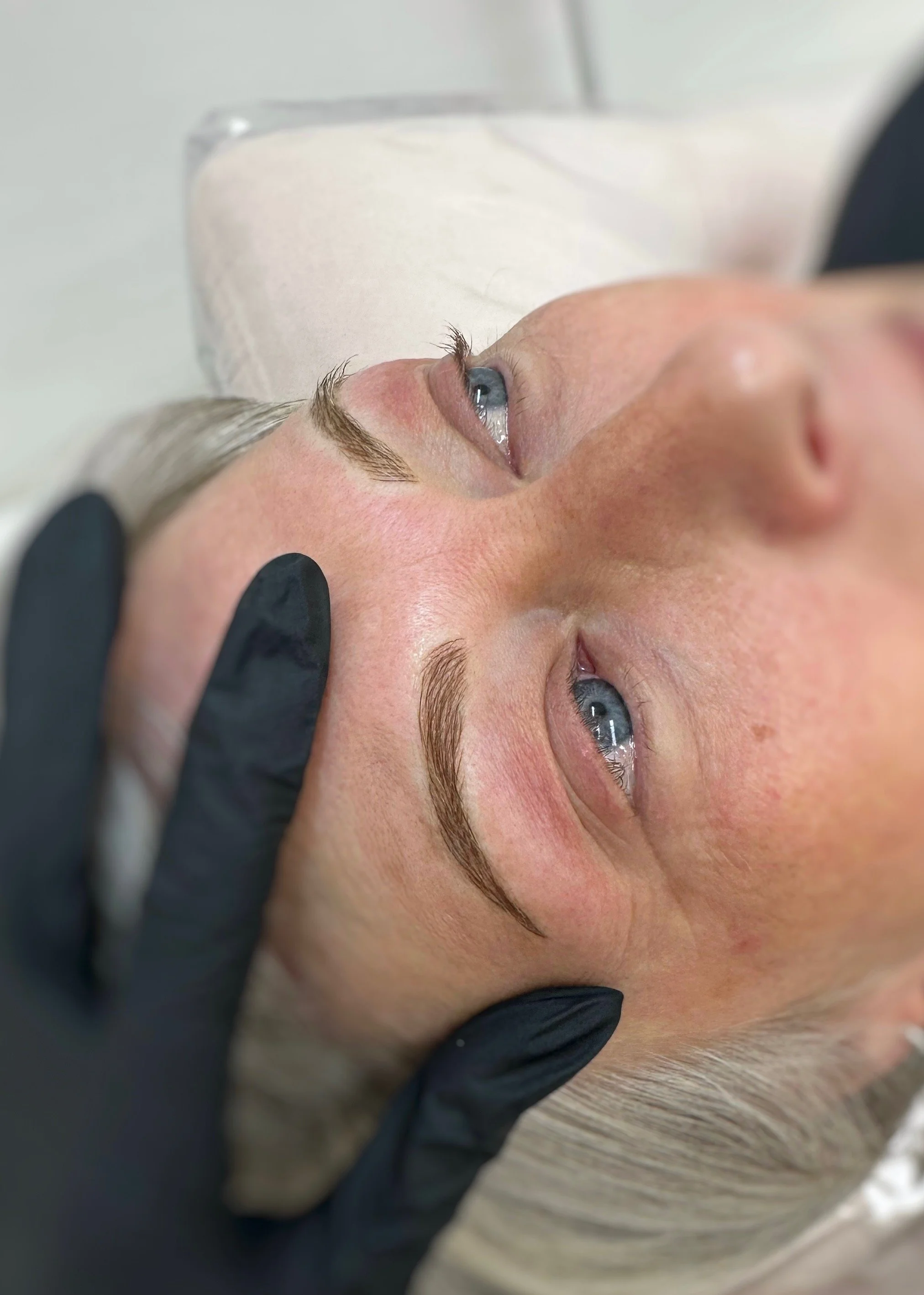 Close-up of a woman’s eyes during an eye examination by a gloved clinician