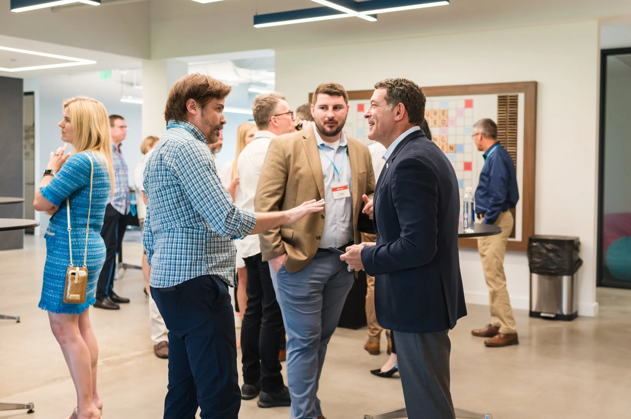 People engaging in conversations at a professional networking event in an office space.