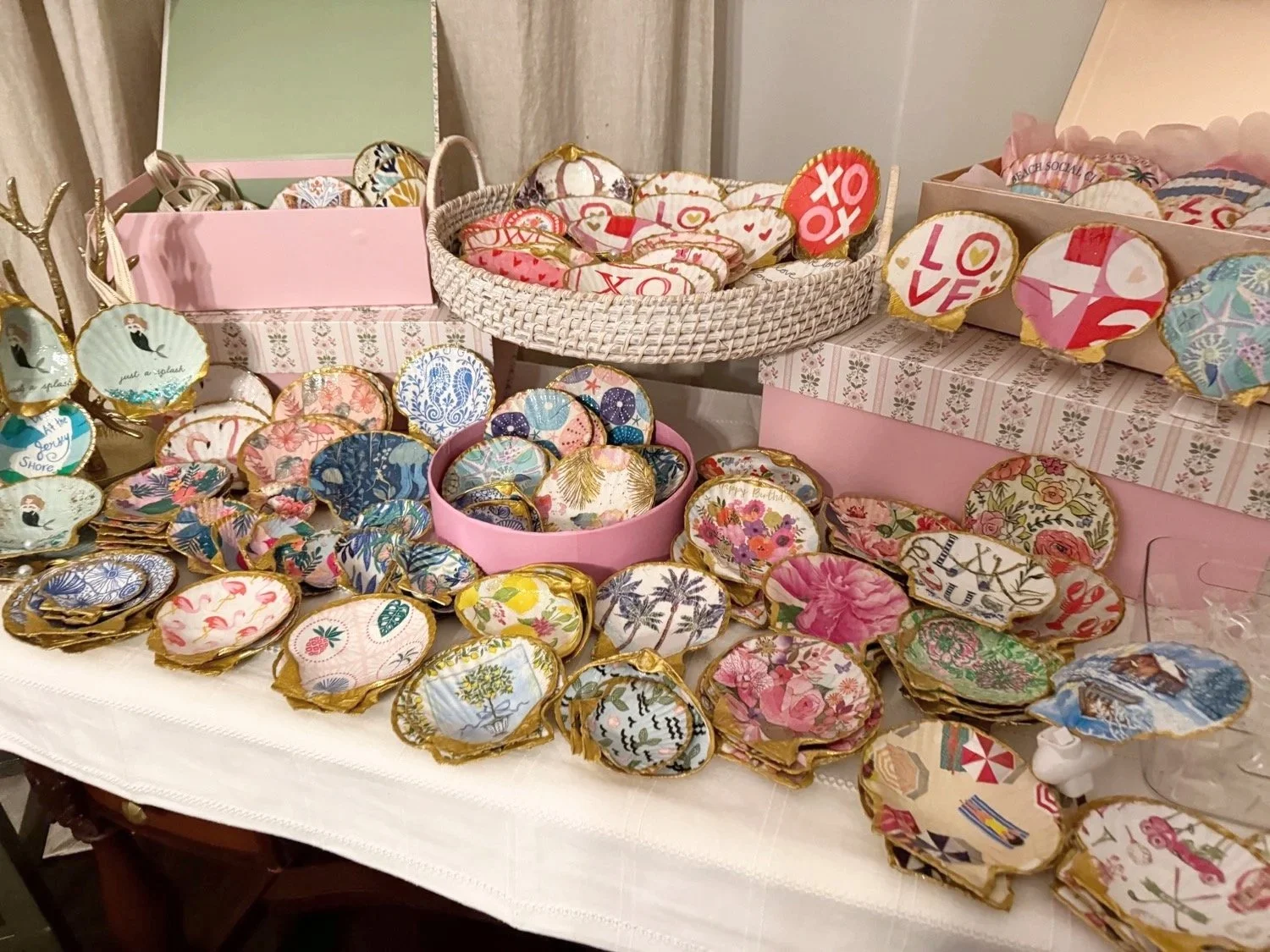 Display of decorated brooches or pins with various floral, animal, and decorative patterns on a table.