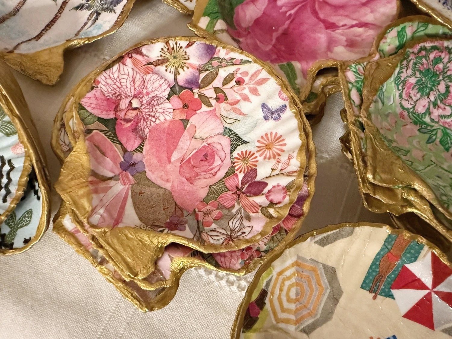 Decorative fabric masks with floral and colorful patterns, trimmed with gold fringe.