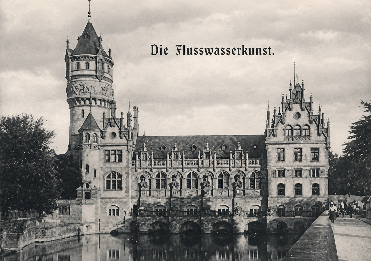 Die Flusswasserkunst in Hannover mit Fluss im Vordergrund, Turm links, gotische Architektur, schwarz-weiß Foto.