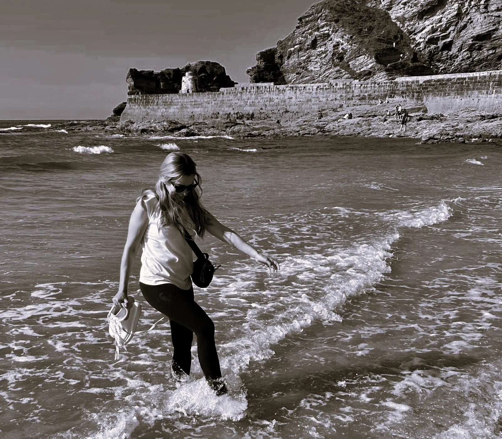 A women on the beach splashing in the water