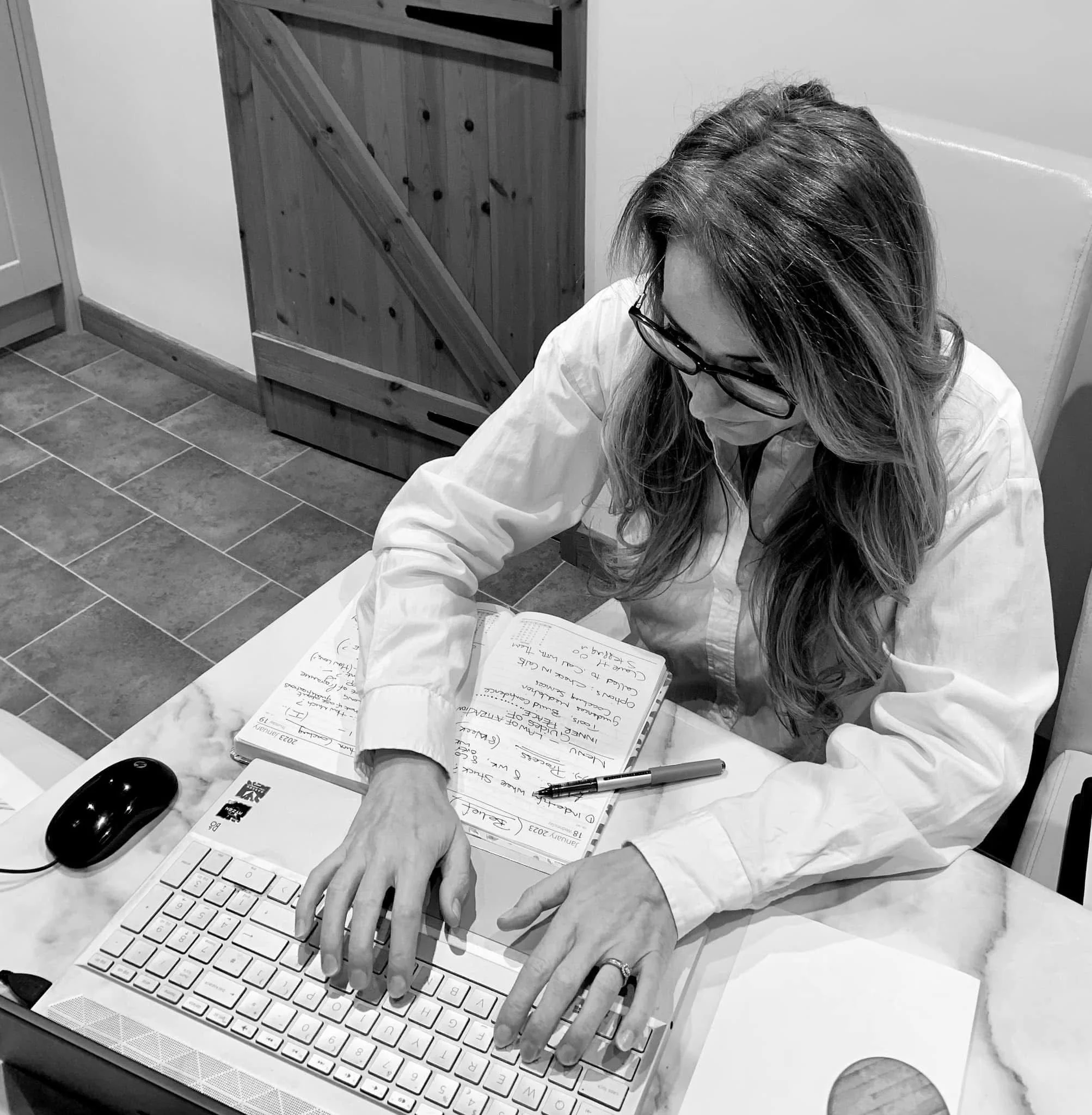 A women looking and typing on a laptop in black and white