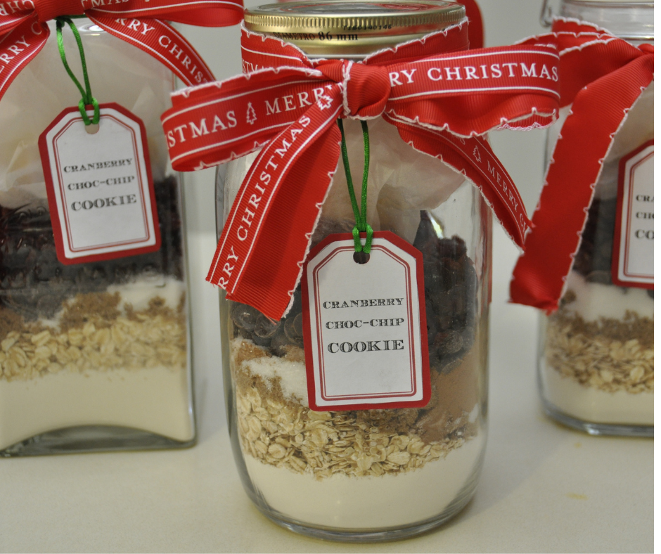 Mason jar filled with ingredients to make cranberry chocolate chip cookies