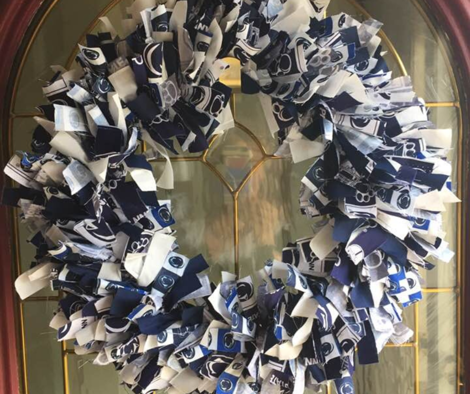 Rag wreath hanging on front door made out of blue, white & Penn State Nittany Lion fabric