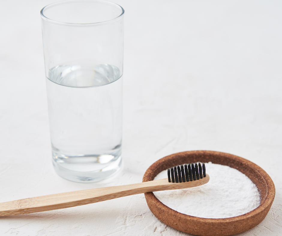 Baking soda with toothbrush and glass of water