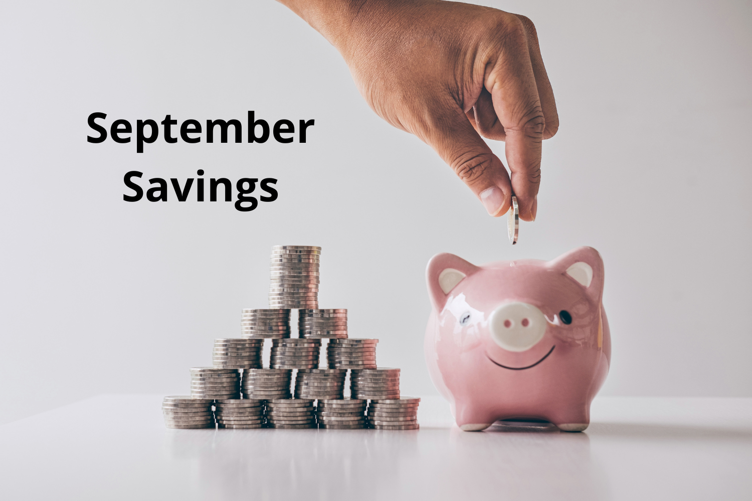 September Savings piggy bank with stacks of coins