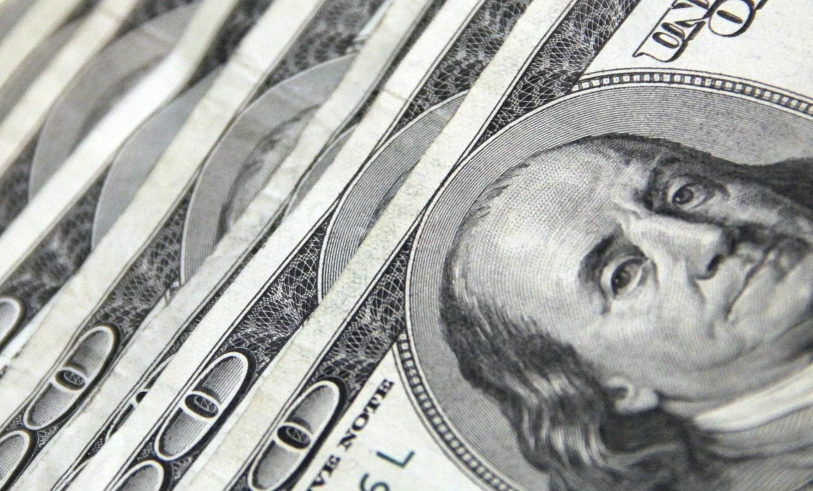 Pile of one hundred dollar bills fanned out