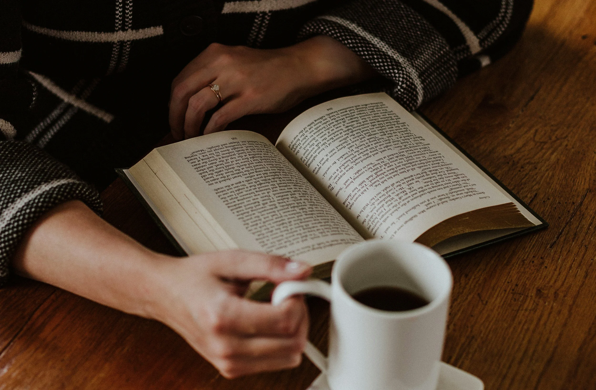 woman reading a financial book and drinking coffee