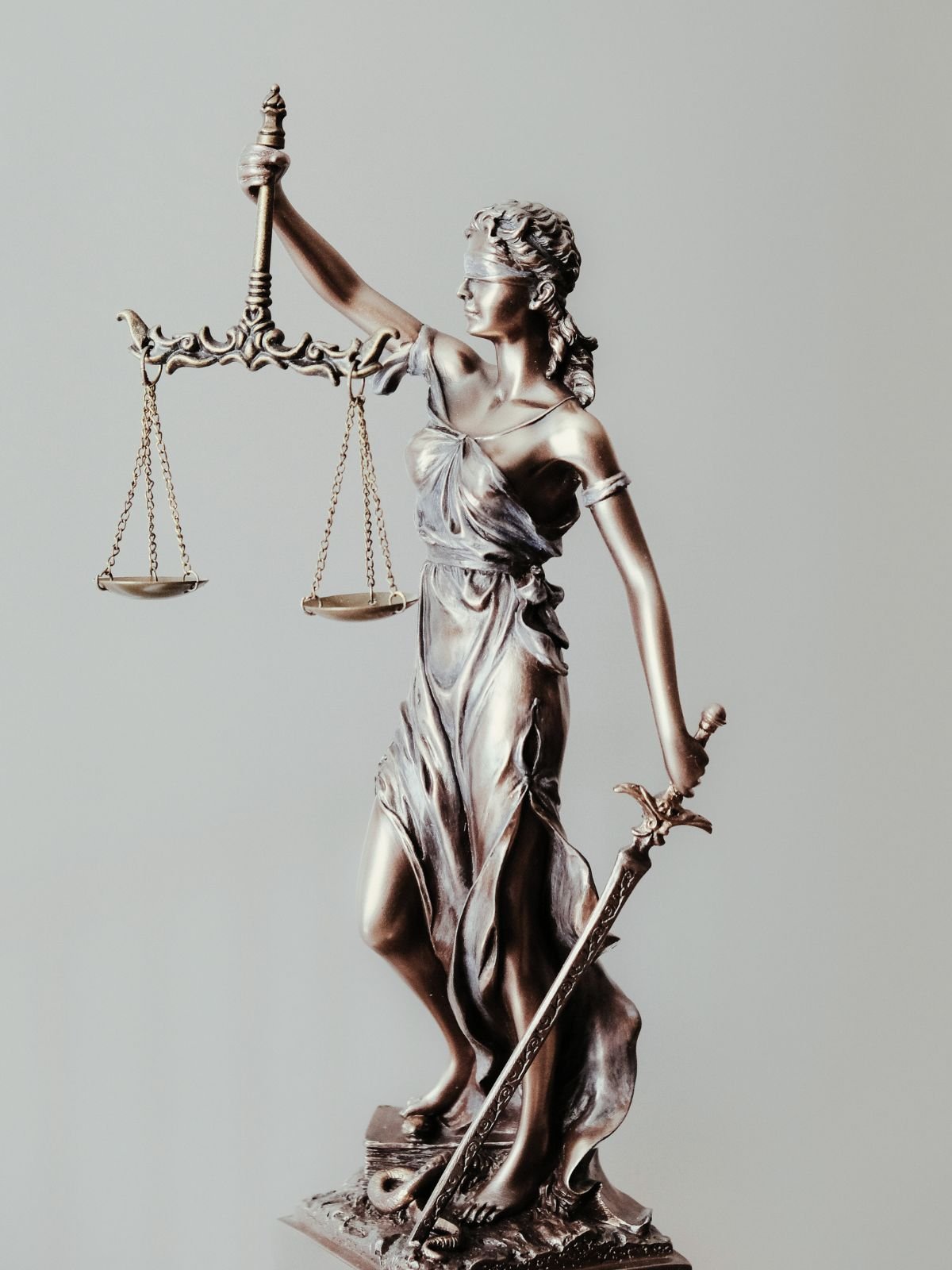 Statue of Lady Justice with a blindfold, holding scales in one hand and a sword in the other.
