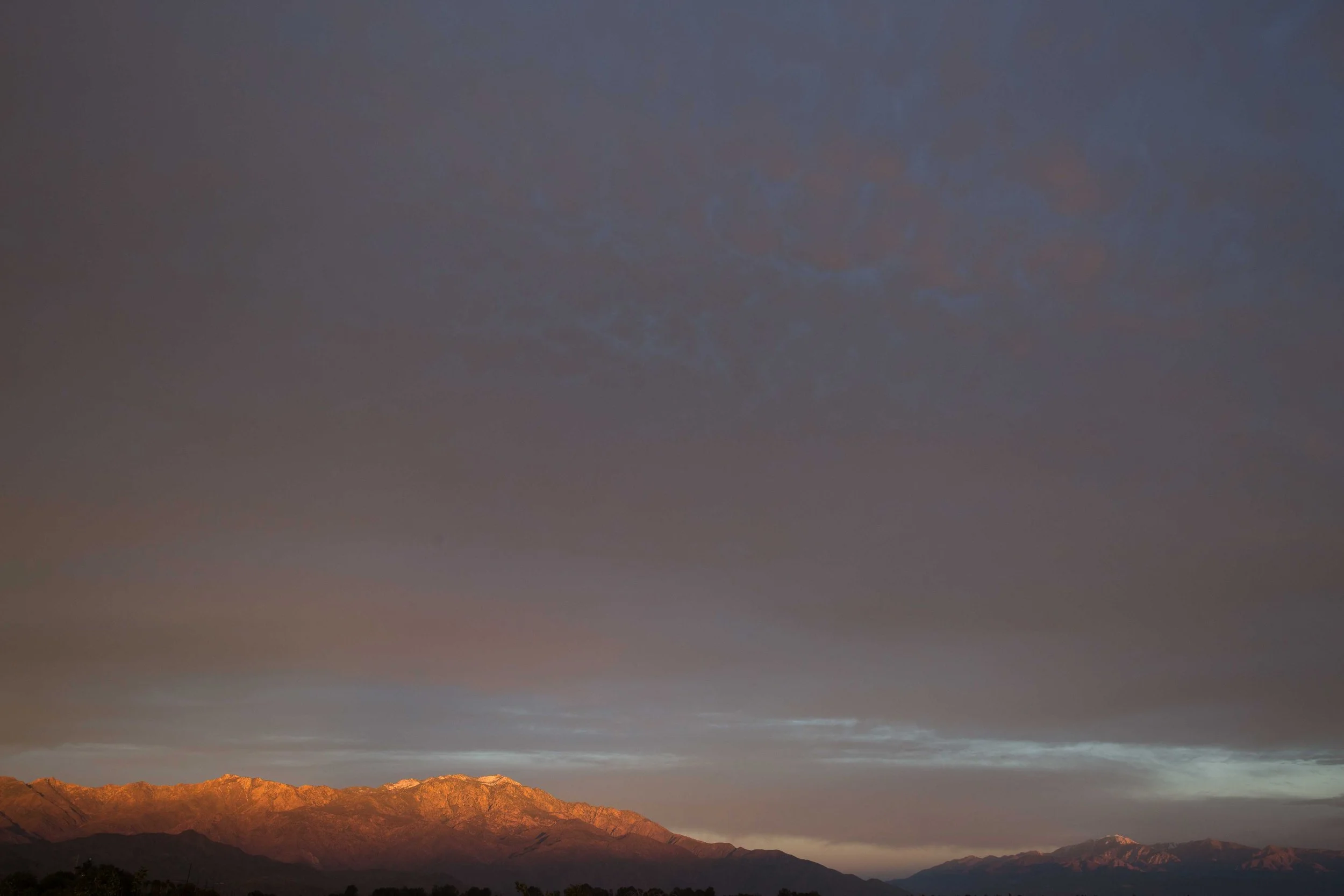 Mountains at dusk with a partly cloudy sky