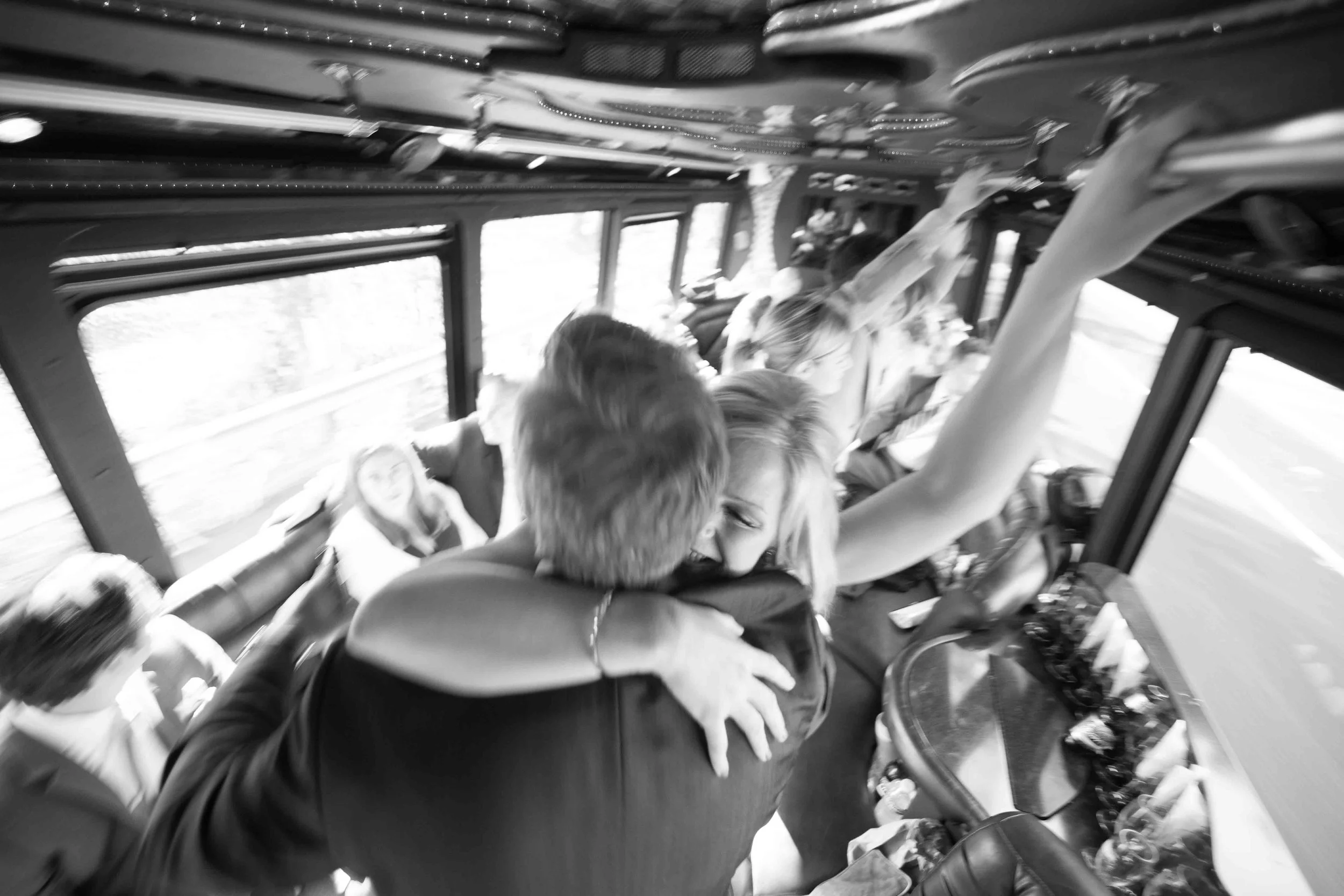 People embracing and celebrating on a bus, with some smiling and hugging.