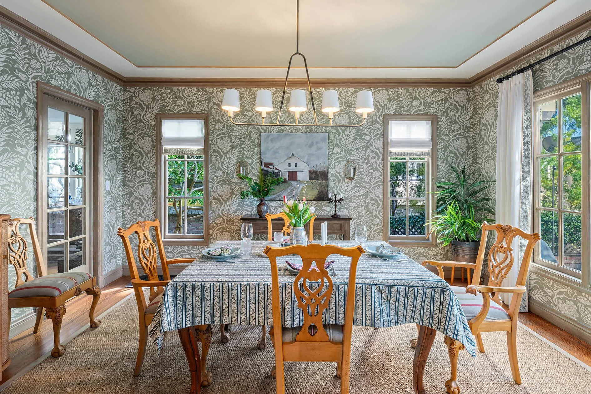 Pattern-filled inviting diningroom with wooden chairs and complimentary table cloth.