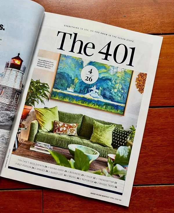 Open magazine page featuring a home decor article titled "The 401". The page displays a vibrant living room with a green sofa, colorful pillows, a large painting of a seascape, and greenery in the foreground.