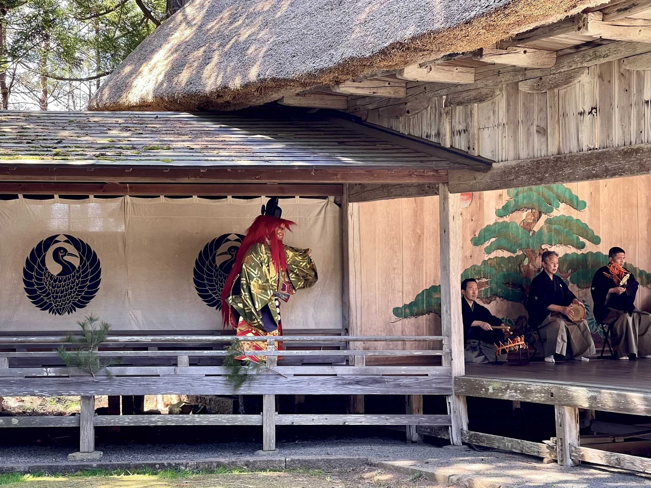 Masked deity crossing the hashigakari bridgeway during a Noh performance on Sado Island